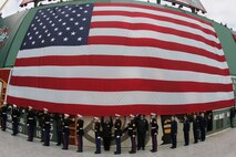 BOSTON -- Marines from 1st Battalion, 25th Marine Regiment, stand under an American Flag draped over the Green Monster, Fenway Park's unique 37 foot tall left field wall, before marching off the field after a pre-game ceremony for the 2010 Bridgestone NHL Winter Classic, Jan. 1. The Air Force provided a B-2 fly over to culminate the pre-game event.(Official Marine Corps photo by Sgt. Randall A. Clinton)