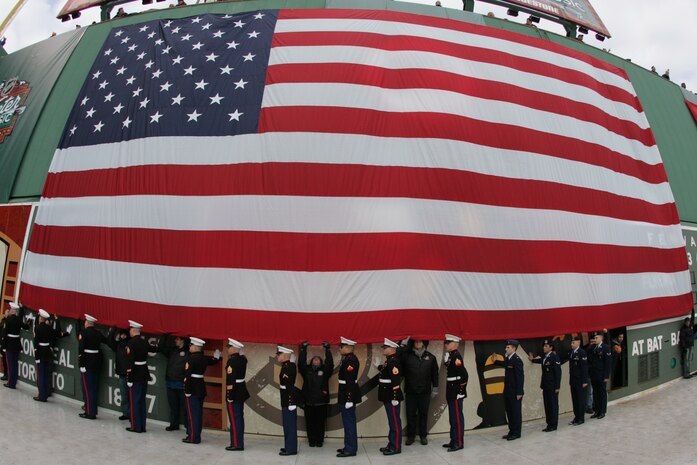 BOSTON -- Marines from 1st Battalion, 25th Marine Regiment, stand under an American Flag draped over the Green Monster, Fenway Park's unique 37 foot tall left field wall, before marching off the field after a pre-game ceremony for the 2010 Bridgestone NHL Winter Classic, Jan. 1. The Air Force provided a B-2 fly over to culminate the pre-game event.(Official Marine Corps photo by Sgt. Randall A. Clinton)