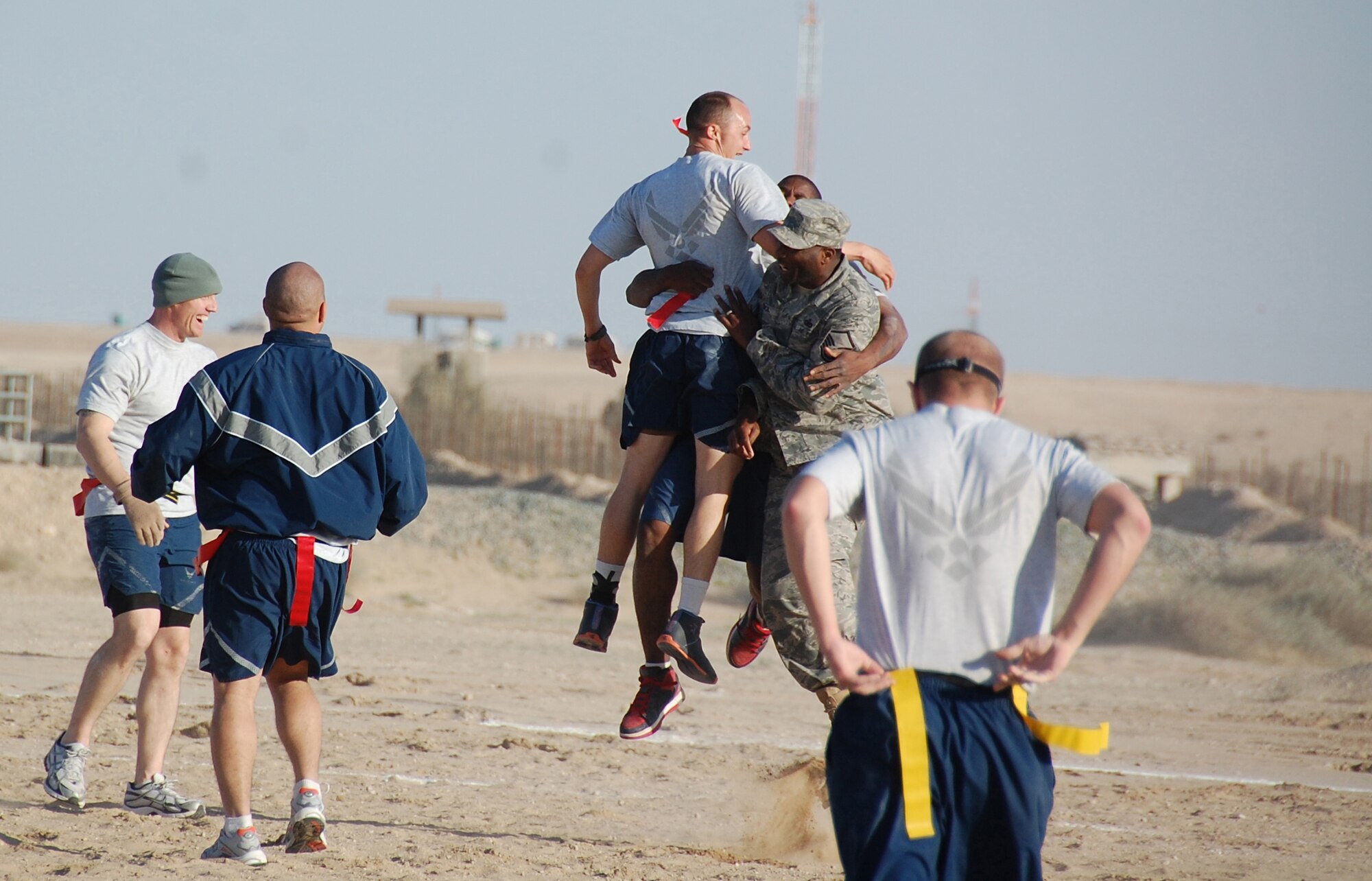 Senior Airman James Finley (left), Senior Airman Charles Tyler and Master Sgt. Dana Council, 386th Expeditionary Security Forces Squadron, celebrate a security forces touchdown during the New Year's Day Dust Bowl championship game Jan. 1, 2010 at an air base in Southwest Asia. The 386th ESFS "Team Grrr" defeated the 386th EMSG 40-20 for the flag football tournament trophy. (U.S. Air Force photo/Staff Sgt. Lindsey Maurice)