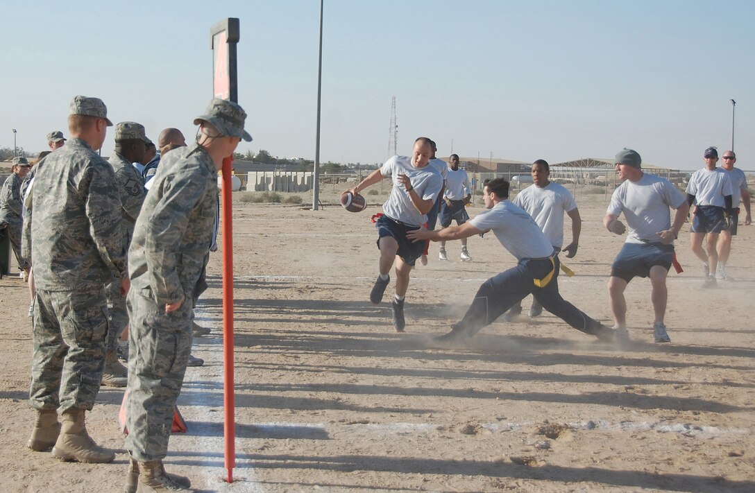 U.S. Air Force Senior Airman James Finley, 386th Expeditionary Security Forces Squadron, runs past the 386th Expeditionary Mission Support Group defense for a touchdown Jan. 1, 2010 during the New Year's Day Dust Bowl Tournament at an air base in Southwest Asia. The 386th ESFS defended its title in the 10-team, single elimination flag football tournament, defeating the 386th EMSG 40-20. (U.S. Air Force photo by Staff Sgt. Lindsey Maurice/Released)