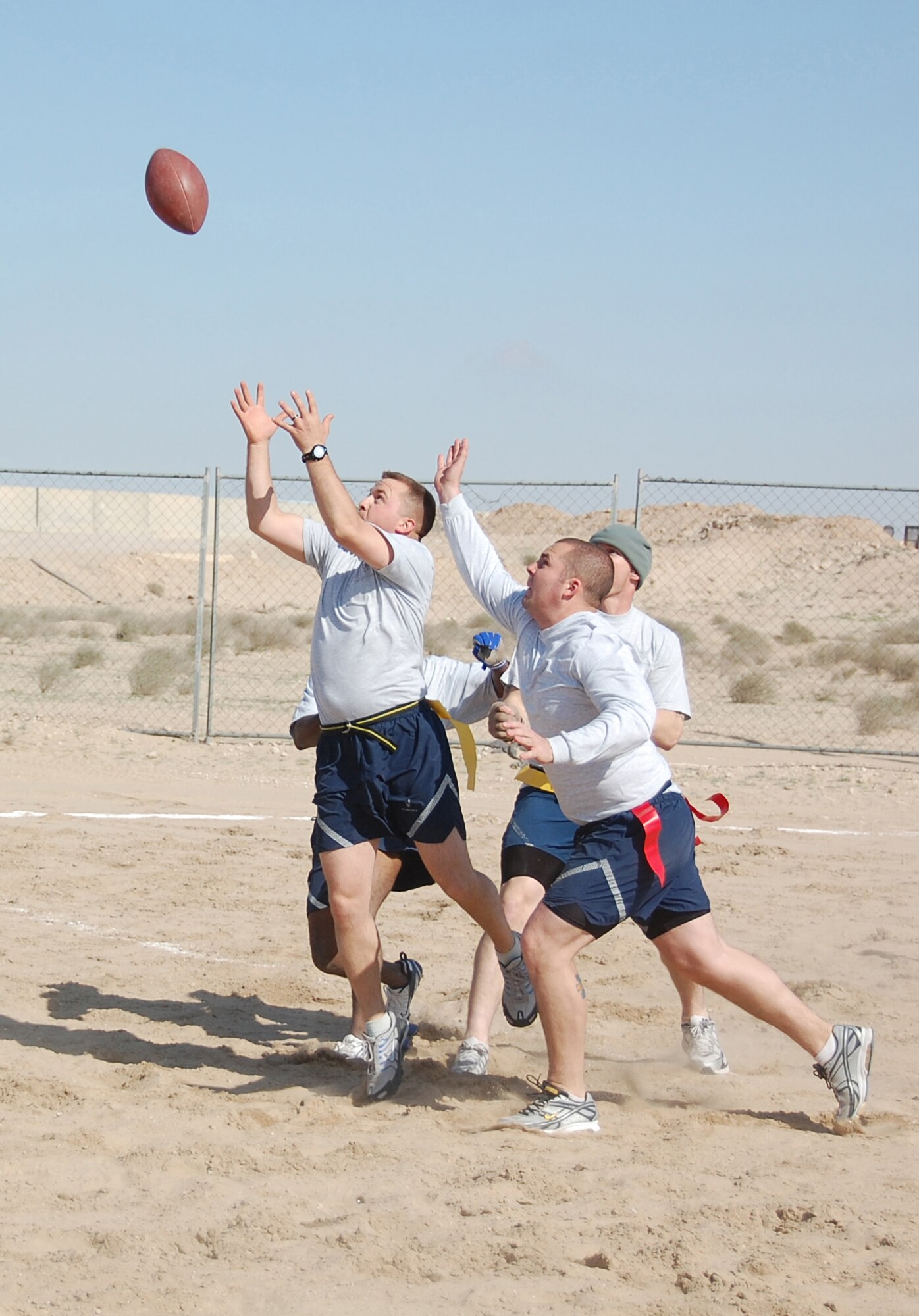 Staff Sgt. Brian Schwartz, (left) 386th Expeditionary Security Forces Squadron, vies with other players to catch a hail mary during the New Year's Day Dust Bowl championship game Jan. 1, 2010 at an air base in Southwest Asia. The 386th ESFS defended its flag football title against the 386th Expeditionary Mission Support Group 40-20. (U.S. Air Force photo/Staff Sgt. Lindsey Maurice)
