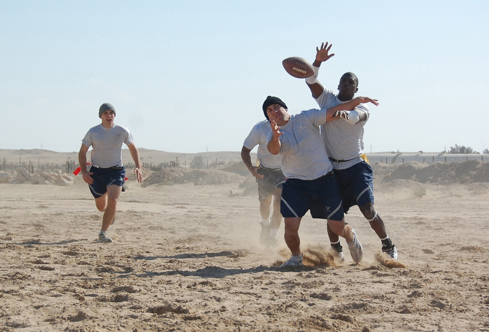 Senior Airman Robert Gantz, (middle) 737th Expeditionary Airlift Squadron, vies for the ball against 386th Expeditionary Mission Support Group opposition during a semi-finals New Year's Day Dust Bowl game Jan. 1, 2010 at an air base in Southwest Asia. The 386th EMSG defeated the 737th EAS 7-0. (U.S. Air Force photo/Staff Sgt. Lindsey Maurice)