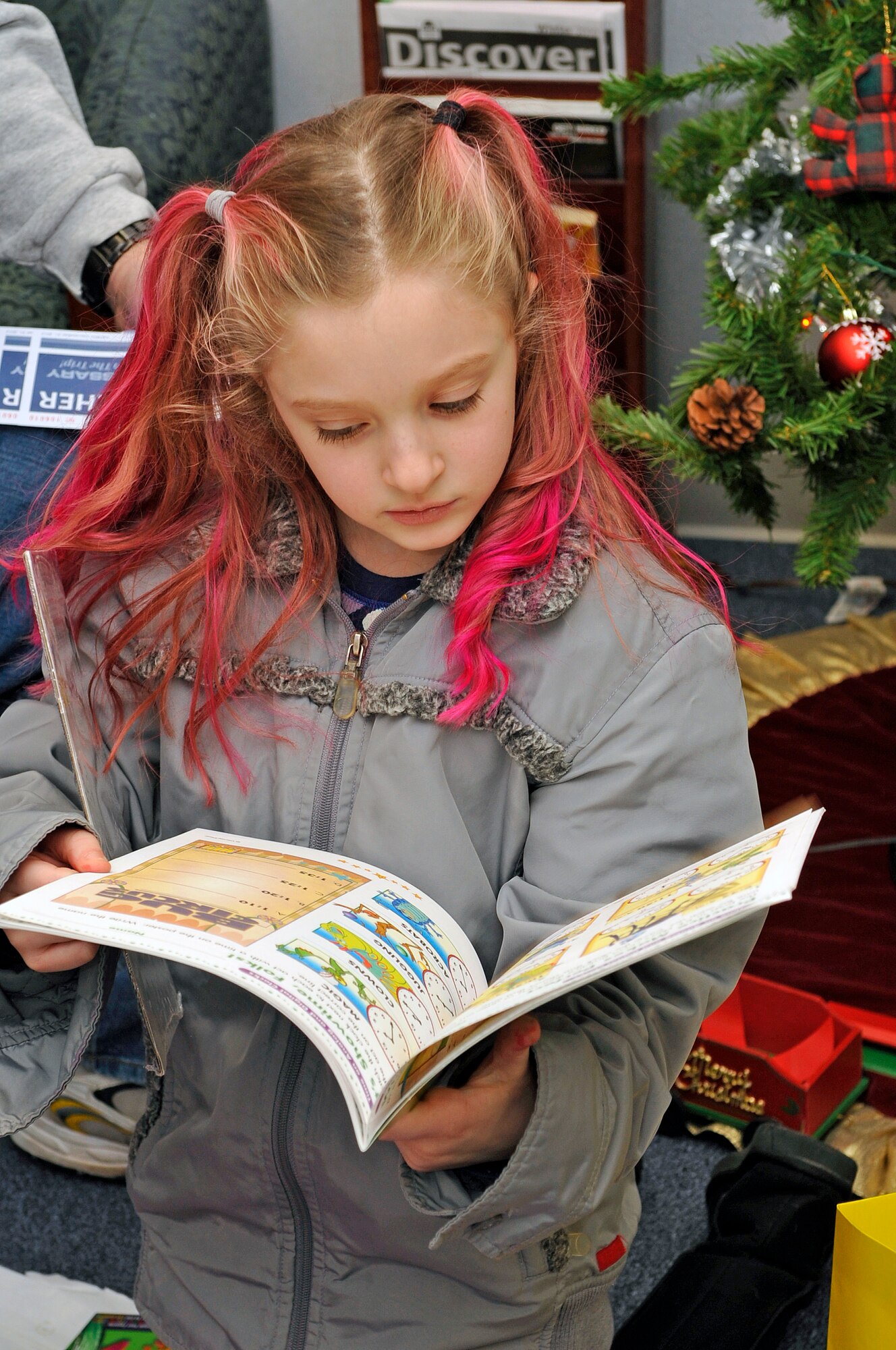 FAIRCHILD AIR FORCE BASE, Wash. – Cami Brown looks at the book she received as a Christmas gift from the Airman and Family Readiness Center here Dec. 22.  Their stolen U-Haul trailer contained everything from Christmas presents to $50,000 in jewelry inside. (U.S. Air Force Photo / Senior Airman Darlene West)
