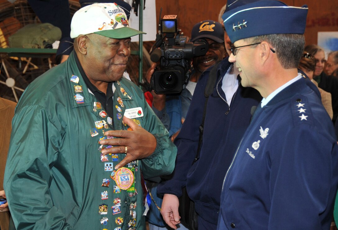 Retired Airman and Tournament of Roses Guide Paul Sherrod talks with SMC Commander Lt. Gen. Tom Sheridan in the Rose Parade float preparation area, Dec. 31. The general visited the float decoration area during the pre-parade fan fest. (Photo by Lou Hernandez)