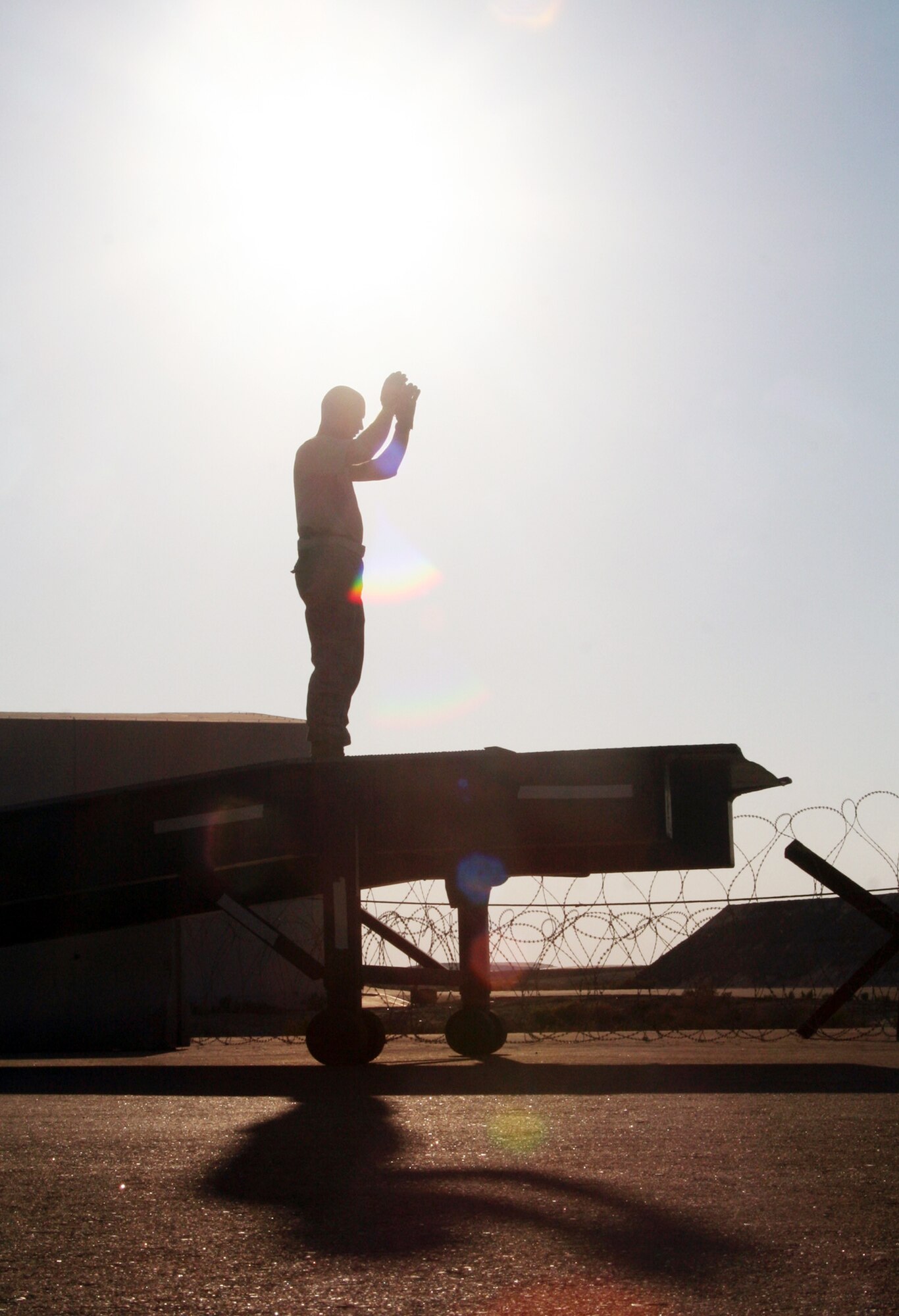 Tech. Sgt. Andrew McMahon directs the loading of a 20,000-pound bus on a loader during operations Dec. 30, 2009, at an air base in Southwest Asia. Sergeant McMahon and five other air transportation Airmen loaded two buses on a Russian-built IL-76 transport which flew the buses to Afghanistan. Sergeant McMahon is the NCO in charge of the 380th Expeditionary Logistics Readiness Squadron Air Terminal Operations Center. (U.S. Air Force photo/Tech. Sgt. Scott T. Sturkol)
