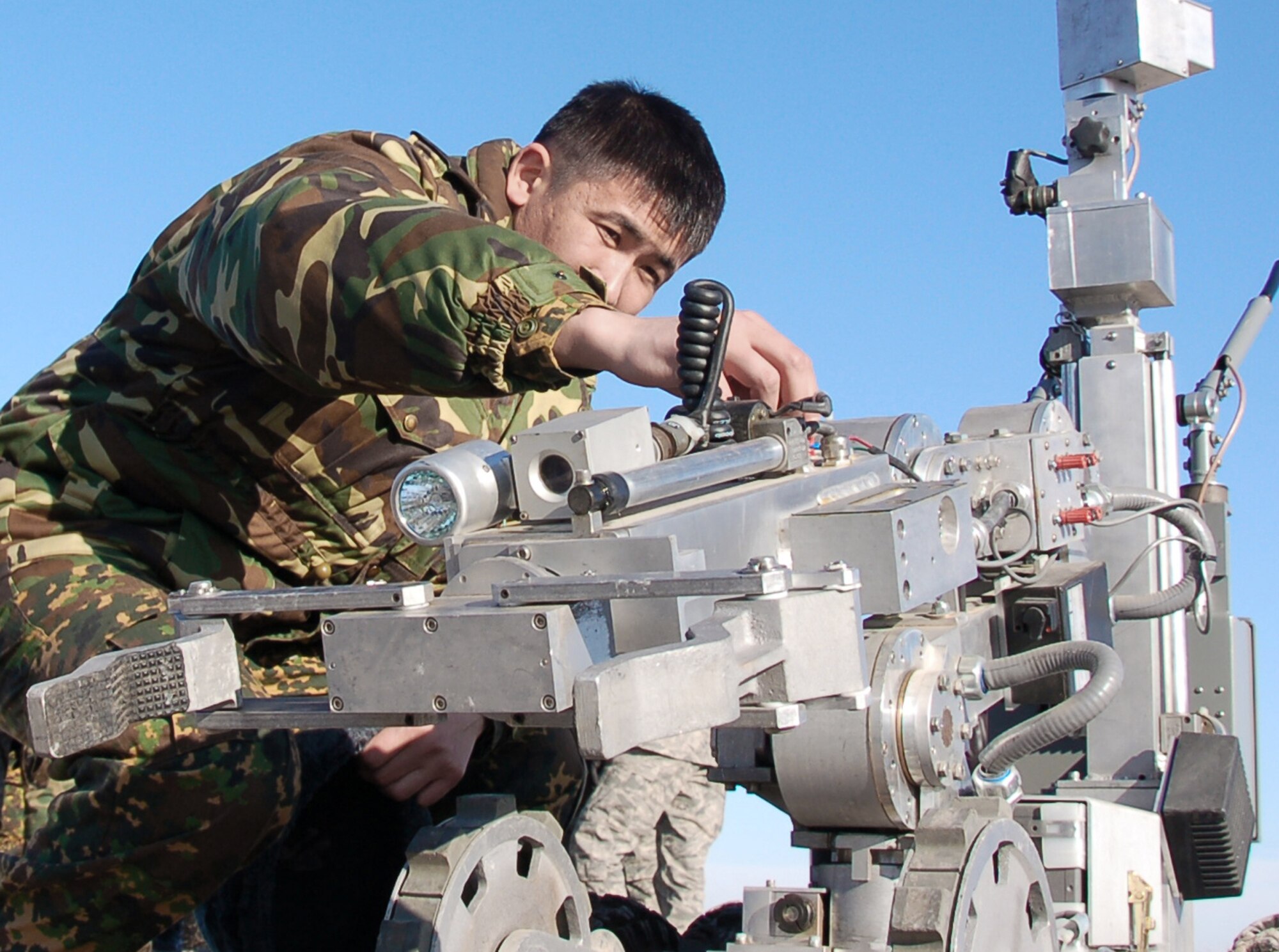 Kyrgyz Capt. Nurgali Baitubaev gets a closer look at an explosive ordnance disposal robot during the Kyrgyz Ministry of Defense team's visit from Dec. 14 to Dec. 18, 2009, to learn about EOD operations from Airmen with the 376th Expeditionary Civil Engineer Squadron at the Transit Center at Manas, Kyrgyzstan. The five-day visit was to help the host nation build a proficient EOD team. (U.S. Air Force photo/Staff Sgt. Olufemi Owolabi)
