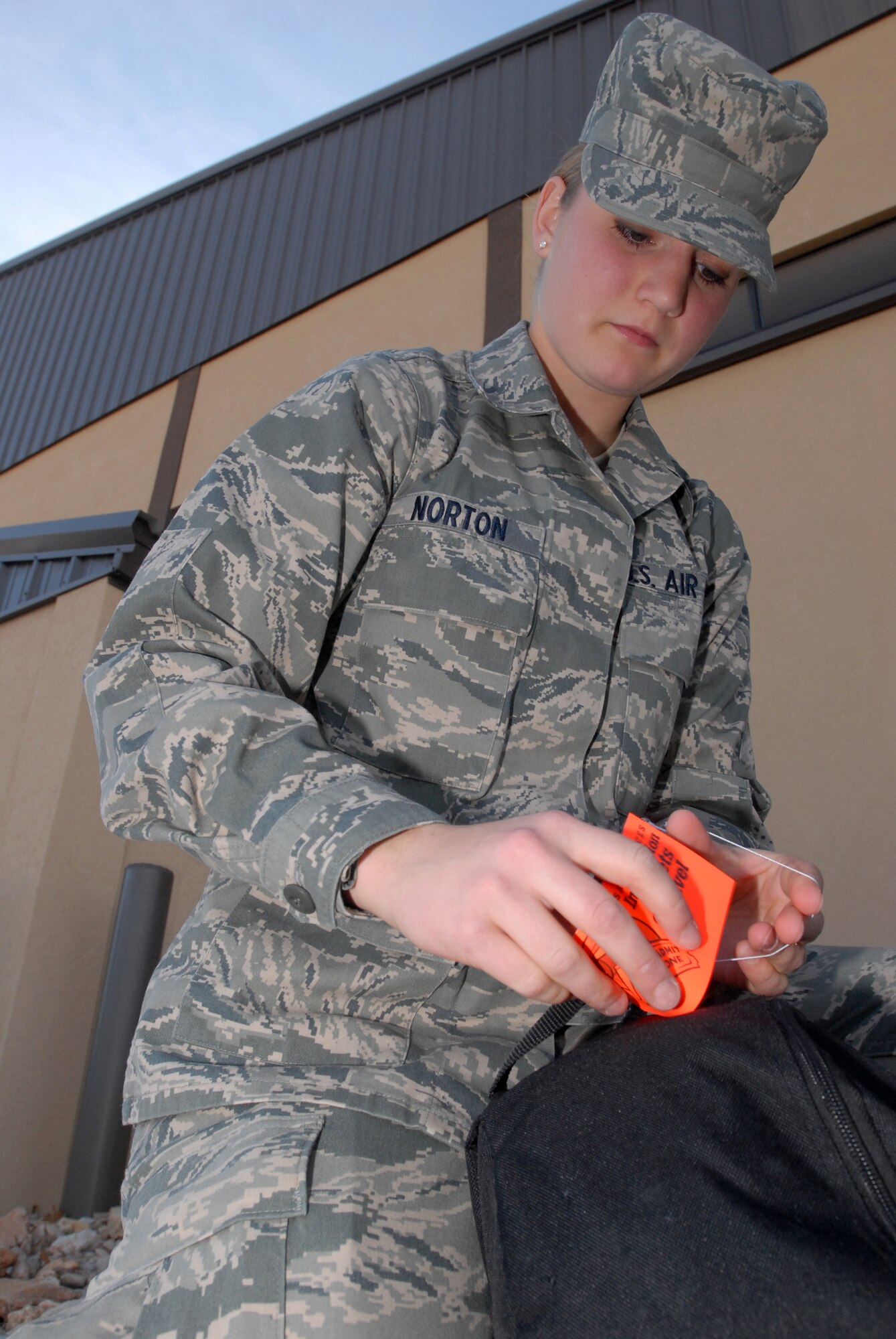 Airman Basic Hannah Norton attaches a luggage tag to one of her bags before she checks in and drops off her luggage prior to leaving Goodfellow AFB, TX for the holidays on Dec. 18.  Airman Basic Norton is assigned to the 312th Training Squadron while going through her technical training at Goodfellow AFB, Texas. Permanent party personnel assisted over 500 military technical training students in traveling home for the holidays during the event known at Goodfellow as Exodus. (US Air Force photo by Master Sgt. Randy Mallard)