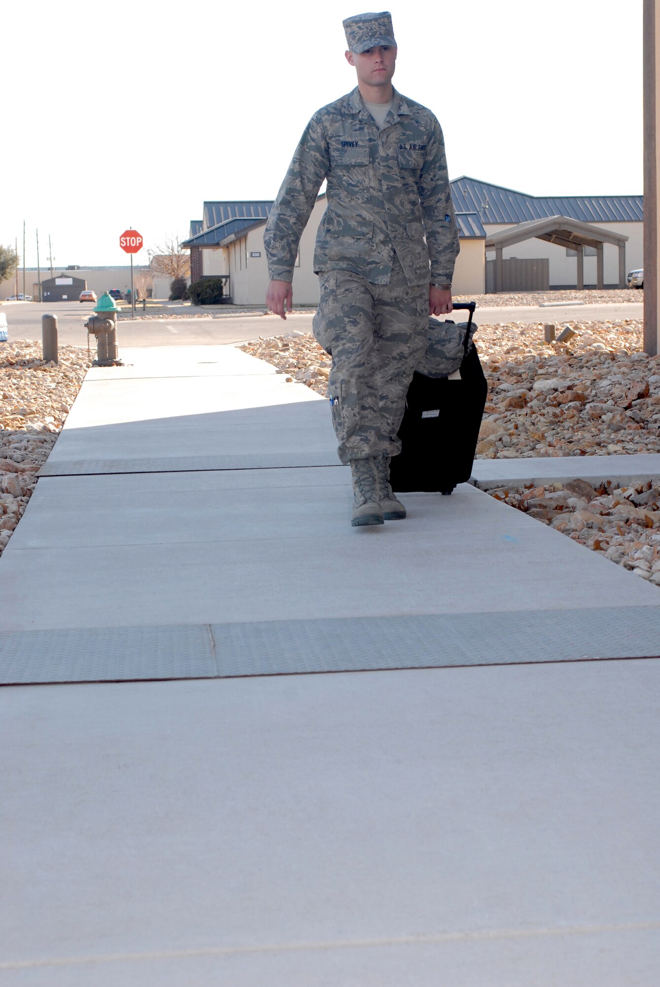Airman Basic Brett Spivey walks to Carswell Field House to check-in and drop off his bag prior to leaving Goodfellow AFB, TX for the holidays on Dec. 18.   Airman Basic Spivey is assigned to the 312th Training Squadron while going through his technical training at Goodfellow AFB, Texas. Permanent party personnel assisted over 500 military technical training students in traveling home for the holidays during the event known at Goodfellow as Exodus. (US Air Force photo by Master Sgt. Randy Mallard)