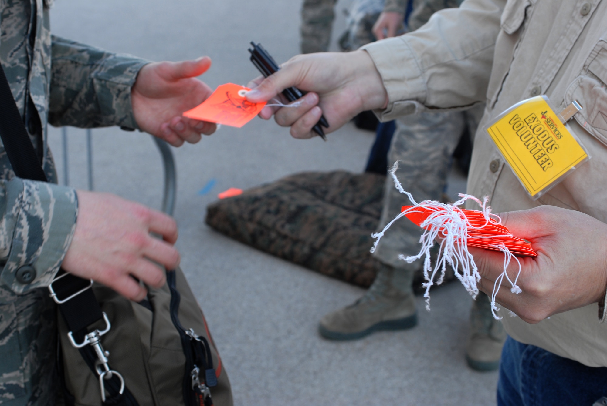 An Exodus volunteer gives an Airman a luggage tag before they check-in and drop off their baggage prior to leaving Goodfellow AFB, Texas for the holidays on Dec. 18. Permanent party personnel assisted over 500 military technical training students in traveling home for the holidays during the event known at Goodfellow as Exodus. (US Air Force photo by Master Sgt. Randy Mallard)