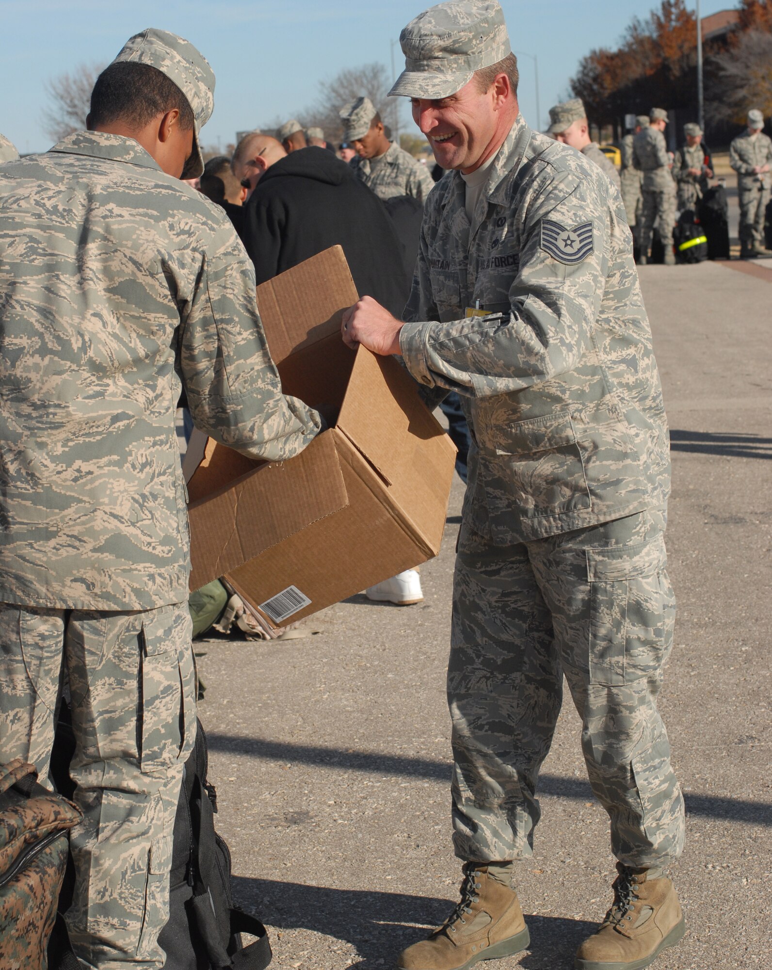 Technical Sergeant James Fountain, 17 Training Wing Safety, hands out cookies to an Airmen standing in line outside Carswell Field House waiting to check-in and drop off their baggage prior to leaving Goodfellow AFB, Texas for the holidays on Dec. 18. Permanent party personnel assisted over 500 military technical training students in traveling home for the holidays during the event known at Goodfellow as Exodus. (US Air Force photo by Master Sgt. Randy Mallard)