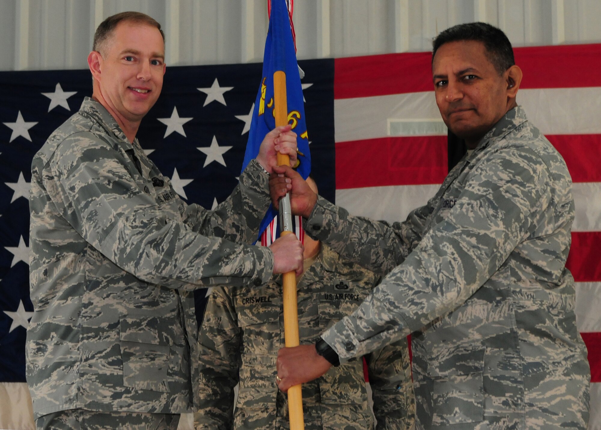 Col. John R. Gordy II, 386th Air Expeditionary Wing commander, passes the 586th Air Expeditionary Group guidon to Col. Jorge Acevedo, 586th AEG commander, during the unit change of command ceremony Jan. 3, 2010 at an air base in Southwest Asia. (U.S. Air Force photo/Staff Sgt. Lakisha A. Croley)