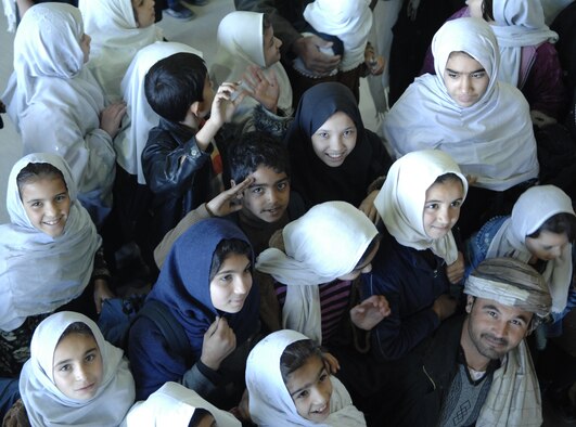 A young Afghan boy renders a salute while standing in a crowd of fellow students and a teacher.  During their visit to Kandahar Airfield Dec. 31, 2009, students were able to see examples of the partnership between coalition forces and Afghan military members working together at the Afghan National Army Air Corps hangar. (U.S. Air Force photo by Staff Sgt. Angelique N. Smythe/Released) 
