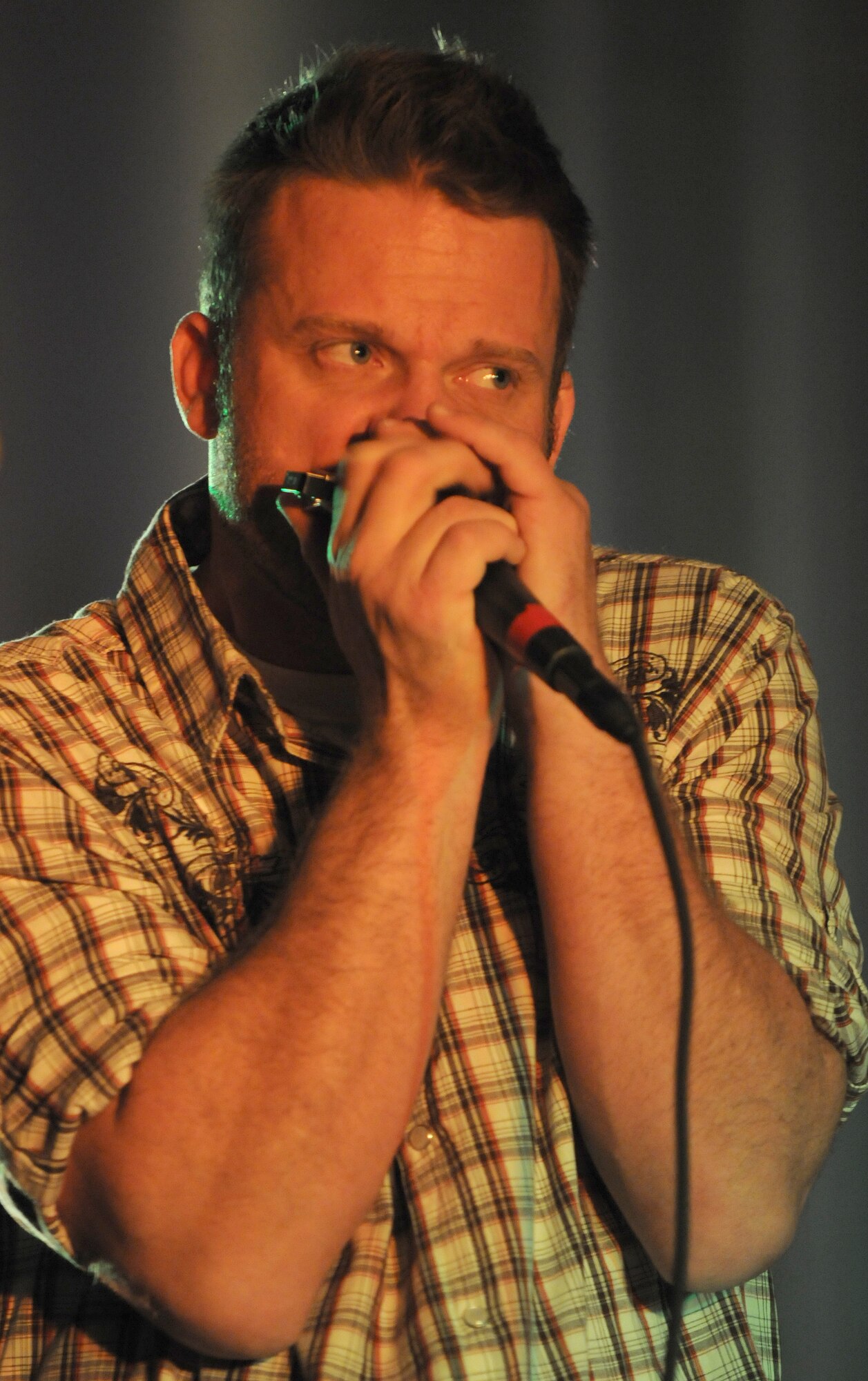 Jimmy Kennedy, lead singer of the Jimmy Kennedy and the Wrecking Ball band, plays the harmonica for a New Years Eve bash Thursday, Dec. 31, 2009 at Incirlik’s consolidated club.  The band visited Incirlik Air Base as part of an Armed Forces Entertainment tour for the troops during the holidays.  (U.S. Air Force photo/Senior Airman Ashley Wood)  