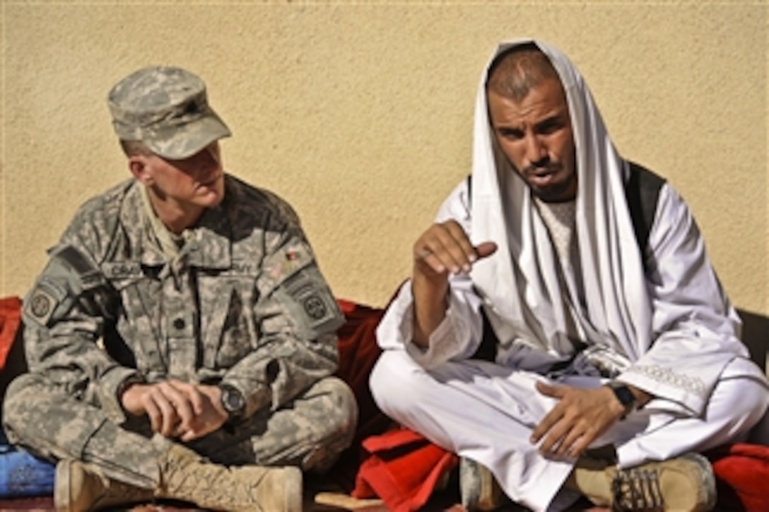U.S. Army Lt. Col. Paul Cravey, with the 3rd Zone Security Forces Advisory Team, meets with Afghan Police Col. Abdul Razzig, commander of the 4th Afghan border police directorate, at the 4th Battalion Headquarters, Kandahar province, Afghanistan, on Dec. 23, 2009.  