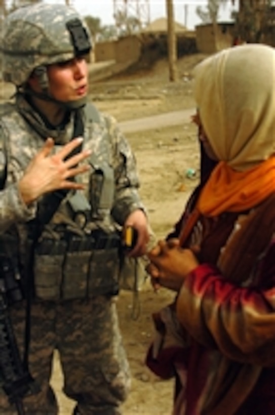 U.S. Army Capt. Marry Nolan, Prevention Medical officer, has a conversation with an Iraqi woman in the village of Sudoor, Diyala, Iraq, on Dec. 18, 2009.  U.S. soldiers and Iraqi army soldiers gave food and school supplies to individuals living in an abandoned hotel.  