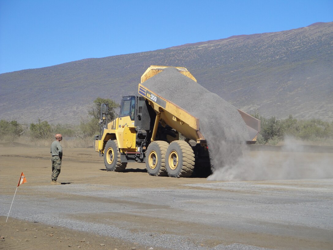 Marines from Marine Wing Support Squadron 171 lay down gravel for the “Cooper’s Airstrip” at the Pohakuloa Training Area in support of Exercise Lava Viper Jan. 4. The runway was created in nine days by 27 Marines and sailors who volunteered their time during their Christmas and New Year’s holiday. The airstrip was created in honor of 1st Lt. Timothy Cooper.