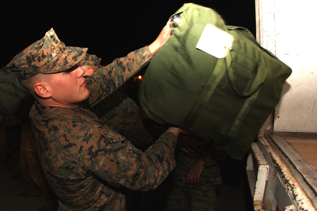 Lance Cpl. Jarrod Larosa, a machine gunner with Company F, 2nd Battalion, 7th Marine Regiment, loads bags onto the back of a truck as the Marines and sailors of his and other companies prepare to leave for the 31st Marine Expeditionary Unit. Second Bn., 7th Marines is the first battalion in itsregiment to deploy with any MEU as a battalion landing team.