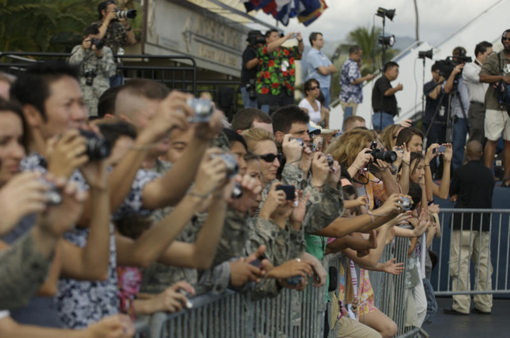 HICKAM AIR FORCE BASE, Hawaii - Airmen and their families take photos of President of the United States Barack Obama and First Lady Michelle Obama as they arrive at Hickam AFB, Hawaii on Dec. 24. President Obama is in Hawaii for the Holidays. (DMA photo by U.S.  Air Force Tech Sgt. Cohen A. Young)