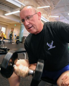 Mike Porter, 12th Force Support Squadron assistant lodging manager, works out with weights at the Rambler Fitness Center recently. Mr. Porter shrunk from a peak of 334 pounds to 198 pounds following bariatric surgery and a strict focus on diet and exercise. (U.S. Air Force photo by Don Lindsey)