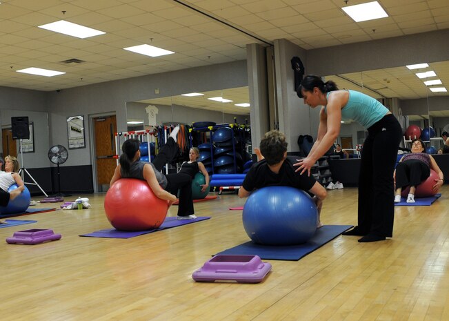 Robyn Sarcomo assists Core Fusion class members at the Fitness and Sports Center here Jan. 4. Ms. Sarcomo is a certified personal trainer and is scheduled to instruct the Core Fusion class Tuesdays, Wednesdays and Thursdays throughout January. Mrs. Sarcomo is the wife of Maj. Gino Sarcomo, 437th Communications Squadron commander. (U.S. Air Force photo/Senior Airman Katie Gieratz)(RELEASED)