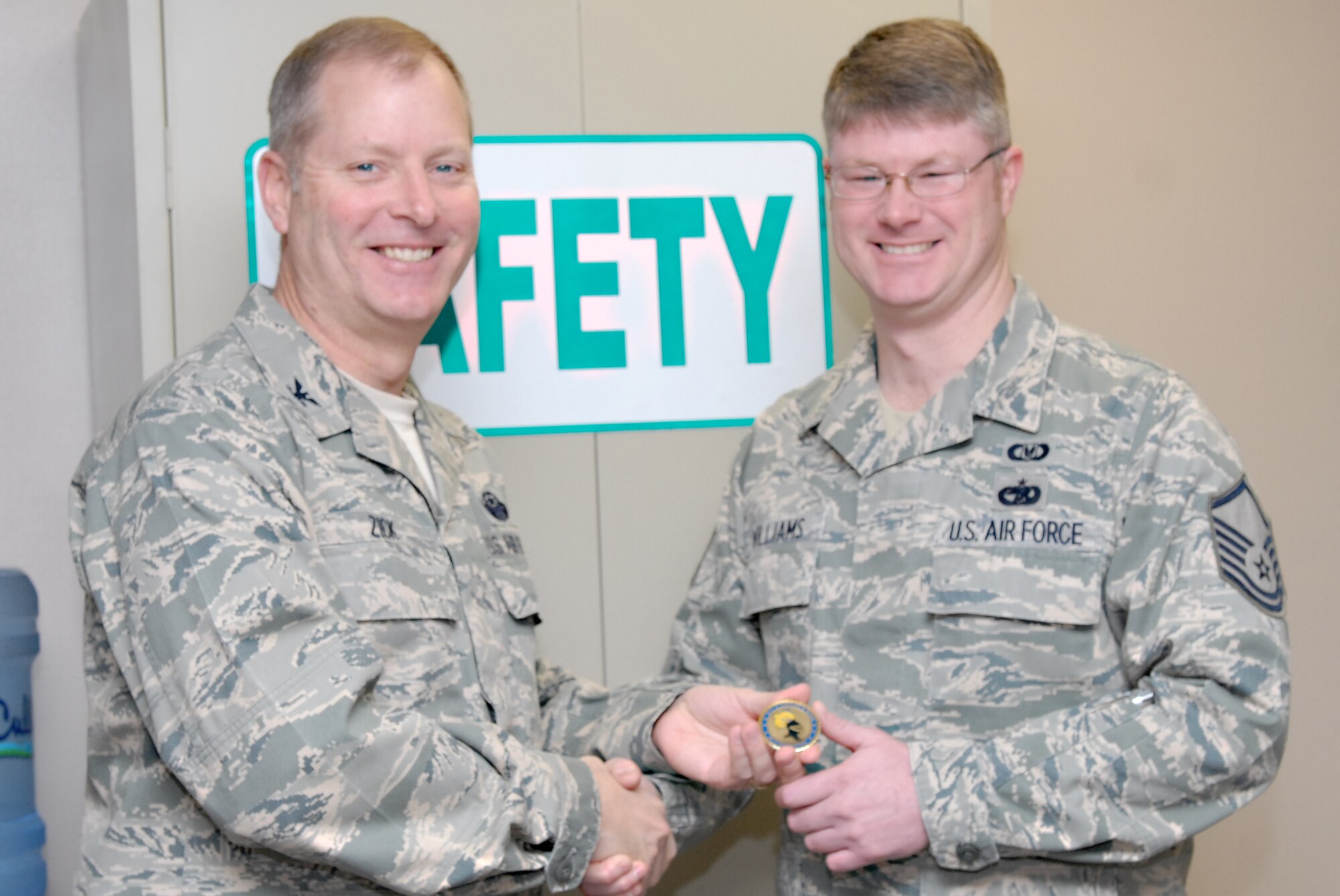 Col. Michael Zick, 19th Airlift Wing vice commander, presents Master Sgt. Donald Williams, 19th Airlift Wing Safety ground safety superintendent, with a commanders coin Jan. 5 for being chosen as the Combat Airlifter of the Week. He led 16 operational risk management classes, trained 350 members for supervising safety and investigated 350 mishaps last year in 2009. (U.S. Air Force photo by Senior Airman Christine Clark)
