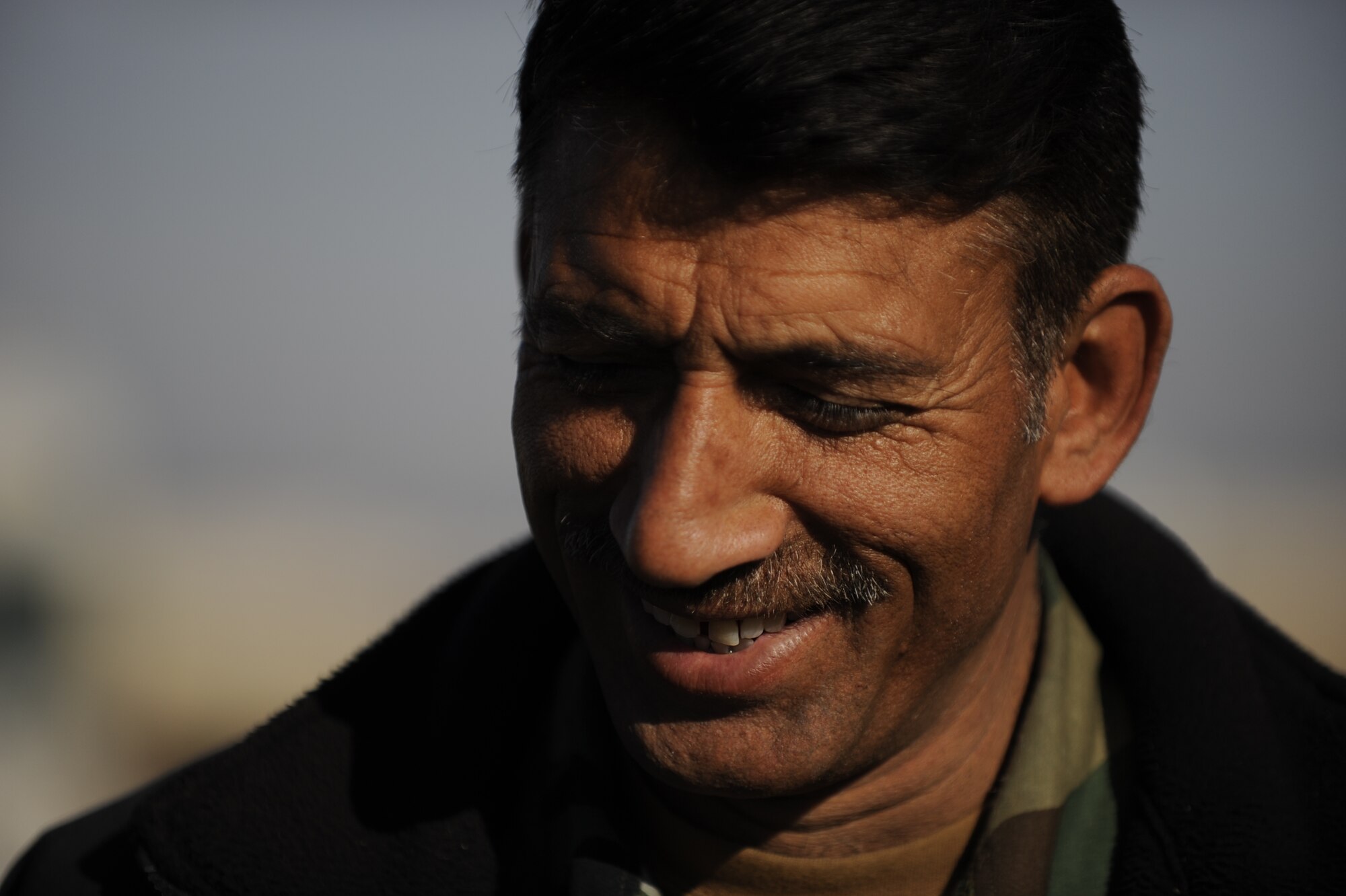 Capt. Shiraf Zal, Afghanistan National Army Air Corps deputy commander, smiles at the improvement of his Soldiers during M-240B machine gun familiarization training in Kandahar, Afghanistan, Jan. 4, 2010.  738th Air Expeditionary Advisory Group Airmen mentor Afghan soldiers as they work to take over their own security. (U.S. Air Force photo/Staff Sgt. Manuel J. Martinez/Released)