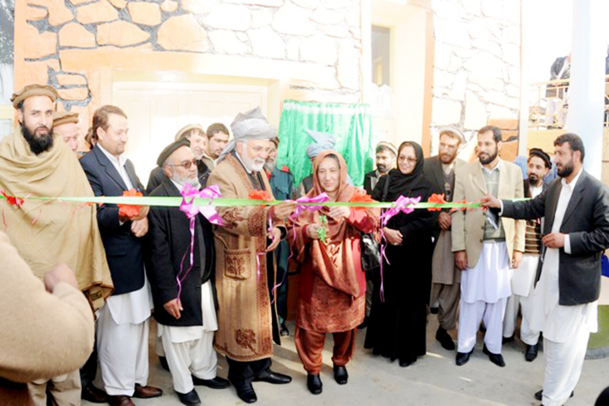 Fazlullah Wahidi, Dr. Asadullah Fazli and Pashtoon Azfar take turns cutting the ribbon commemorating the opening of the Kunar midwifery program training center Dec. 22 in Asadabad, Afghanistan. The midwifery program will train 24 women from Kunar province in an 18-month long course on providing prenatal and postpartum care to expectant mothers and their babies to decrease infant mortality rates. Mr. Wahidi is the Kunar provincial governor. Doctor Fazli is the provincial Director of Public Health. Pashtoon Azfar is the Afghan Midwife Committee chief. (U.S. Air Force photo/Tech. Sgt. Brian Boisvert) 