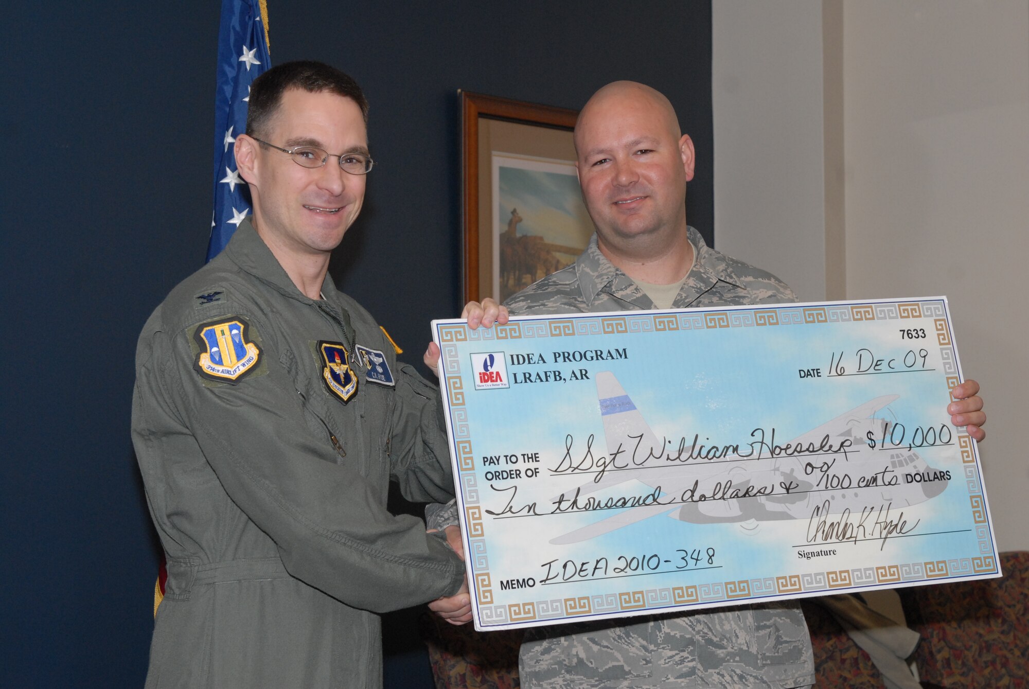 Col. C. K. Hyde, 314th Airlift Wing commander, presents Staff Sgt. William Hoessler, 314th Aircraft Maintenance Squadron communication navigation system craftsman, with a $10,000 check. Sergeant Hoessler submitted his idea through the Innovation Development through Employee Awareness program to replace wheel interphone control system switches. The IDEA program encourages innovative, creative thinking by Department of Defense personnel. Monetary awards are calculated on first year savings and can be as high as $10,000 for each approved idea that results in tangible savings. (U.S. Air Force photo by Senior Airman Christine Clark)