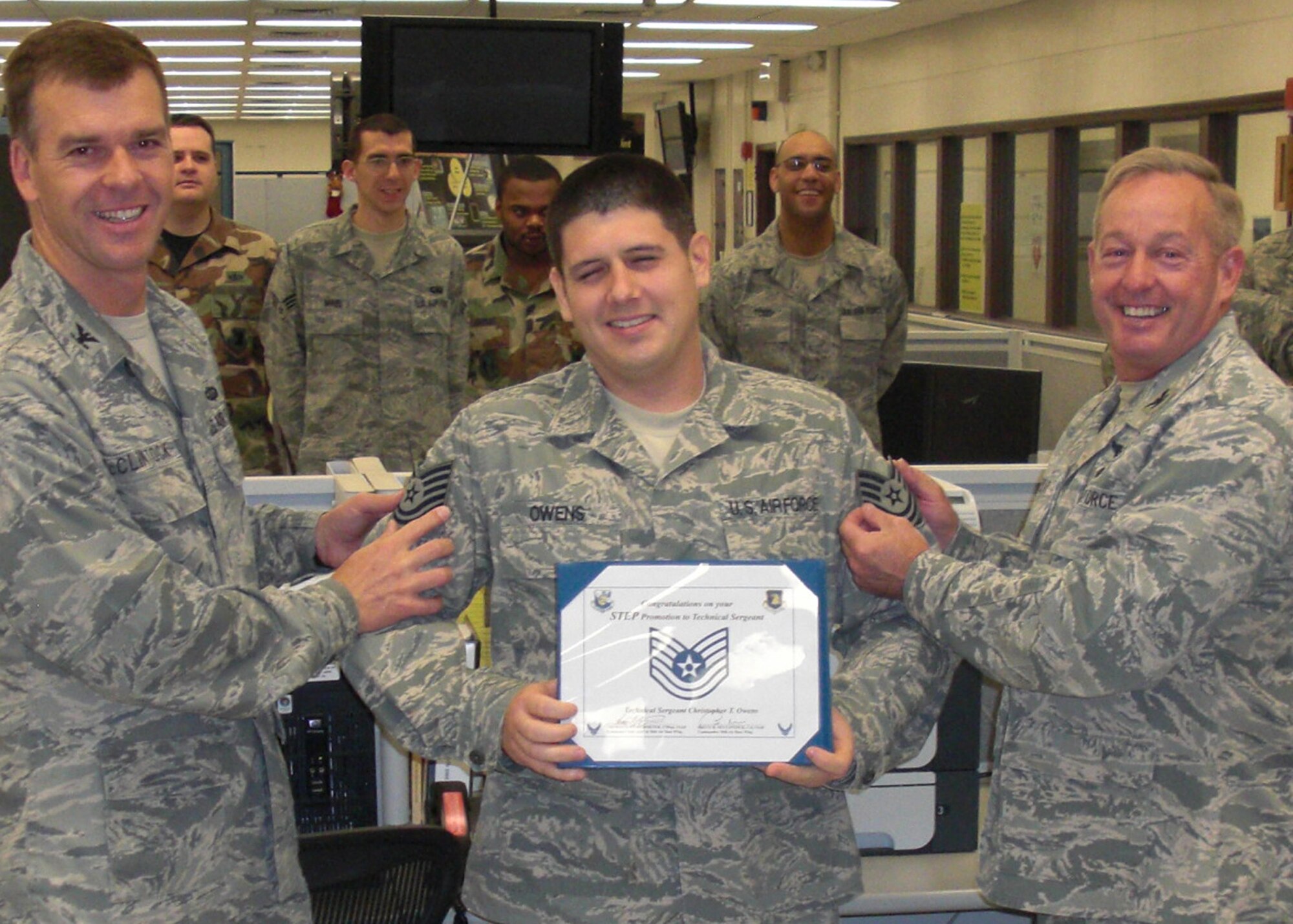 Col. Bruce McClintock, 96th Air Base Wing commander (left), and Col. Stephen O'Rear, 96th Communications Group commander (right) hold up new technical sergeant stripes for Christopher Owens, 96th Communications Squadron, Dec. 24 at Eglin Air Force Base.  He received the new stripes via the Stripes for Exceptional Performers program, an extremely limited promotion avenue available once a year around the Air Force. Eglin had four STEP promotions for 2009. (Courtesy photo)