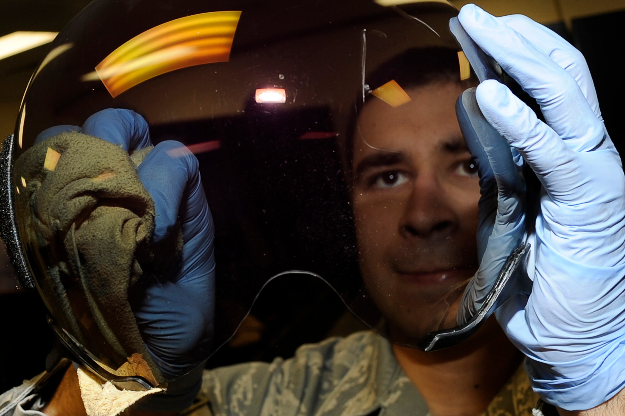 BAGRAM AIRFIELD, Afghanistan-- U.S. Air Force Airman 1st Class Jeremy Botello, aircrew flight equipment specialist, 455th Expeditionary Operations Support Squadron, cleans a lens before a pilot's flight Jan. 4, 2010.  Botello is stationed a Shaw Air Force Base, S.C. and is from Austin, Texas. 
(U.S. Air Force photo by: Tech. Sgt. Jeromy K. Cross)