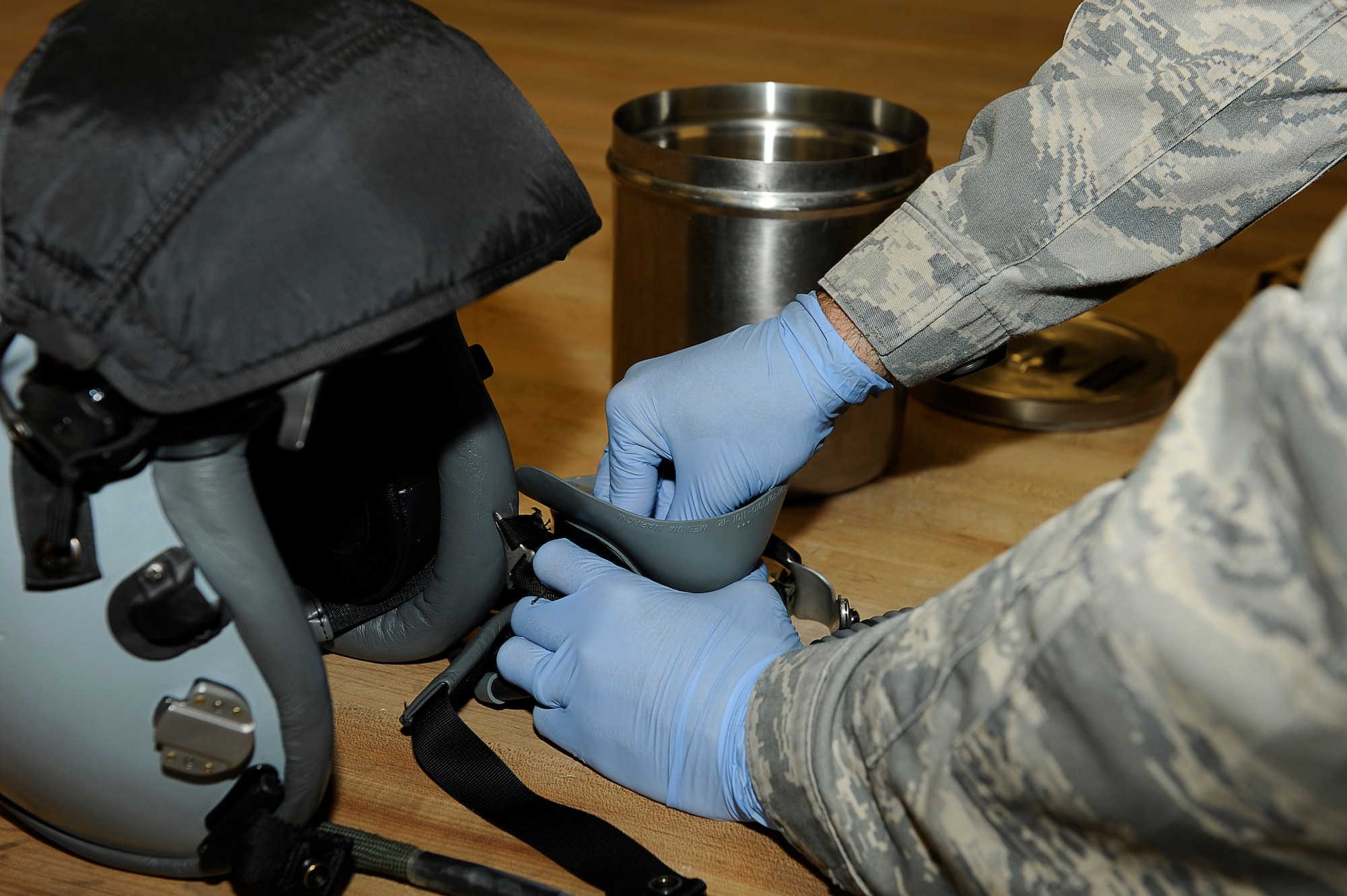 BAGRAM AIRFIELD, Afghanistan-- U.S. Air Force Airman 1st Class Jeremy Botello, aircrew flight equipment specialist, 455th Expeditionary Operations Support Squadron, cleans and prepares a helmet before a pilot's flight Jan. 04, 2010.  Botello is stationed at Shaw Air Force Base, S.C. and is from Austin, Texas. 
(U.S. Air Force photo by: Tech. Sgt. Jeromy K. Cross)