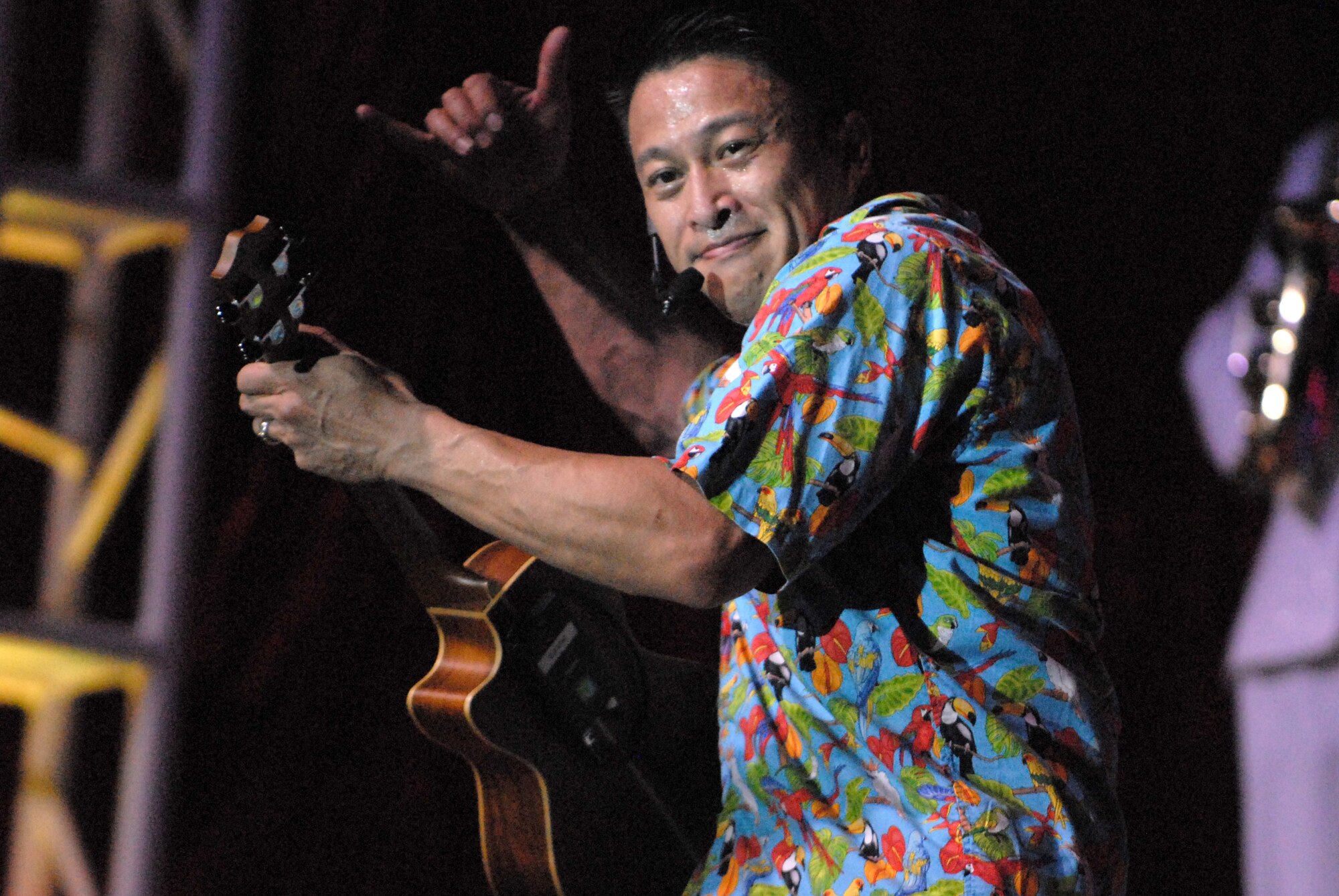 HICKAM AIR FORCE BASE, Hawaii - Master Sgt. Herbert Ancog , Tops In Blue vocalist out of Waialua, Hawaii, waves the "shaka" as he plays the ukelele during a Tops In Blue performance here, Jan. 5. Tops In Blue is an expeditionary entertainment unit that primarly performs for those stationed worldwide at remote and deployed locations. (U.S. Air Force photo/Senior Airman Gustavo Gonzalez)