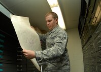MINOT AIR FORCE BASE, N.D. -- Airman 1st Class Shelton Feibel, 5th Civil Engineer Squadron draftsman, reviews a hard copy of a past base project in the drawing vault here Jan. 6. Not only are hard copies kept in the drawing vault, but also digital copies are stored. Members of CES, like engineering assistant apprentices, use various means to help with their work such as Computer Aided Design drawings and surveying technology, which includes GPS. (U.S. Air Force photo by Airman 1st Class Ashley N. Avecilla)