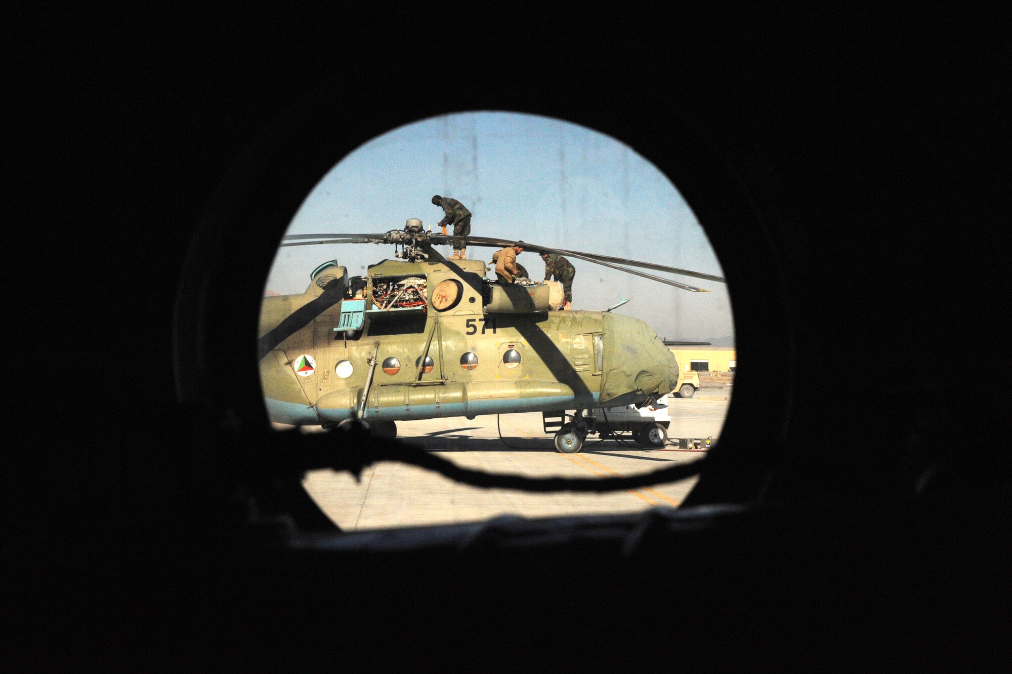 Afghanistan National Army Air Corps soldiers perform routine maintenance on an MI-17 helicopter Jan. 5, 2010 at Kandahar Airfield, Afghanistan. Airmen attached to the 738th Air Expeditionary Adviser Group provide maintenance mentorship for ANAAC Soldiers. (U.S. Air Force photo/Staff Sgt. Manuel J. Martinez)
