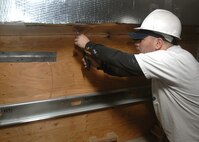 MINOT AIR FORCE BASE, N.D. -- Damion Johnson, a construction worker, places insulation around the new heating system and ducts for the dormitories here Dec. 6. Construction such as this is part of a continuing approach at improving base facilities. (U.S. Air Force photo by Senior Airman Michael J. Veloz)