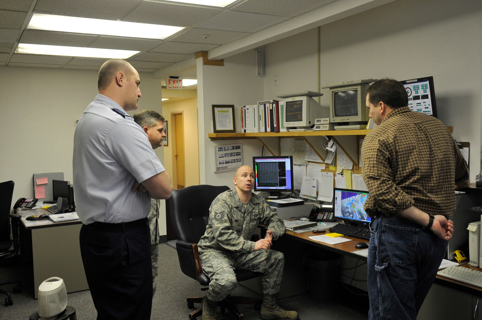 The weather flight discusses the satellite image Dec. 21, 2009, Eielson Air Force Base, Alaska. Through teamwork the team comes to a consensus on what forecast the image is displaying. They are assigned to the 354th Operations Support Squadron weather flight. (U.S. Air Force photo/Airman 1st Class Janine Thibault)