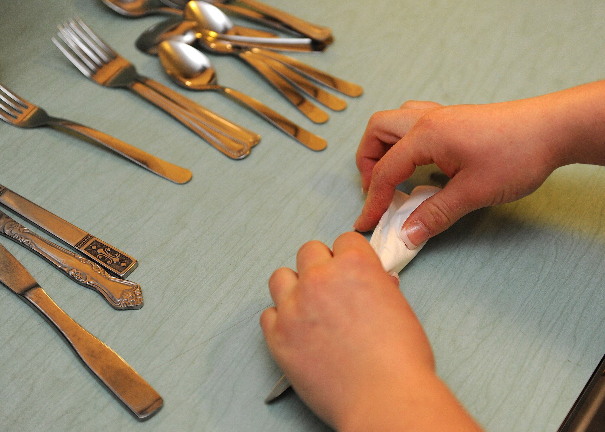 HOLLOMAN AIR FORCE BASE, N.M. -- Airman 1st Class Eileen Payne, 49th Fighter Wing staff, wraps silverware during the soup kitchen at St. John's Episcopal Church, Dec. 17. Airmen from Holloman Air Force Base and members of the community volunteer at the Soup Kitchen which is held twice a week. (U.S. Air Force photo by Senior Airman Michael Means)