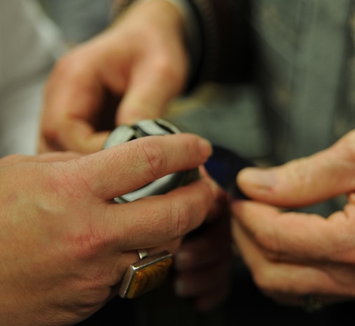 Honorary commanders open a flashlight to look inside during the honorary commander induction here Jan. 5. The induction included a ceremonial induction and Expeditionary Combat Skills Training hosted by the 437th Security Forces Squadron. (U.S. Air Force photo/Senior Airman Katie Gieratz)(RELEASED)