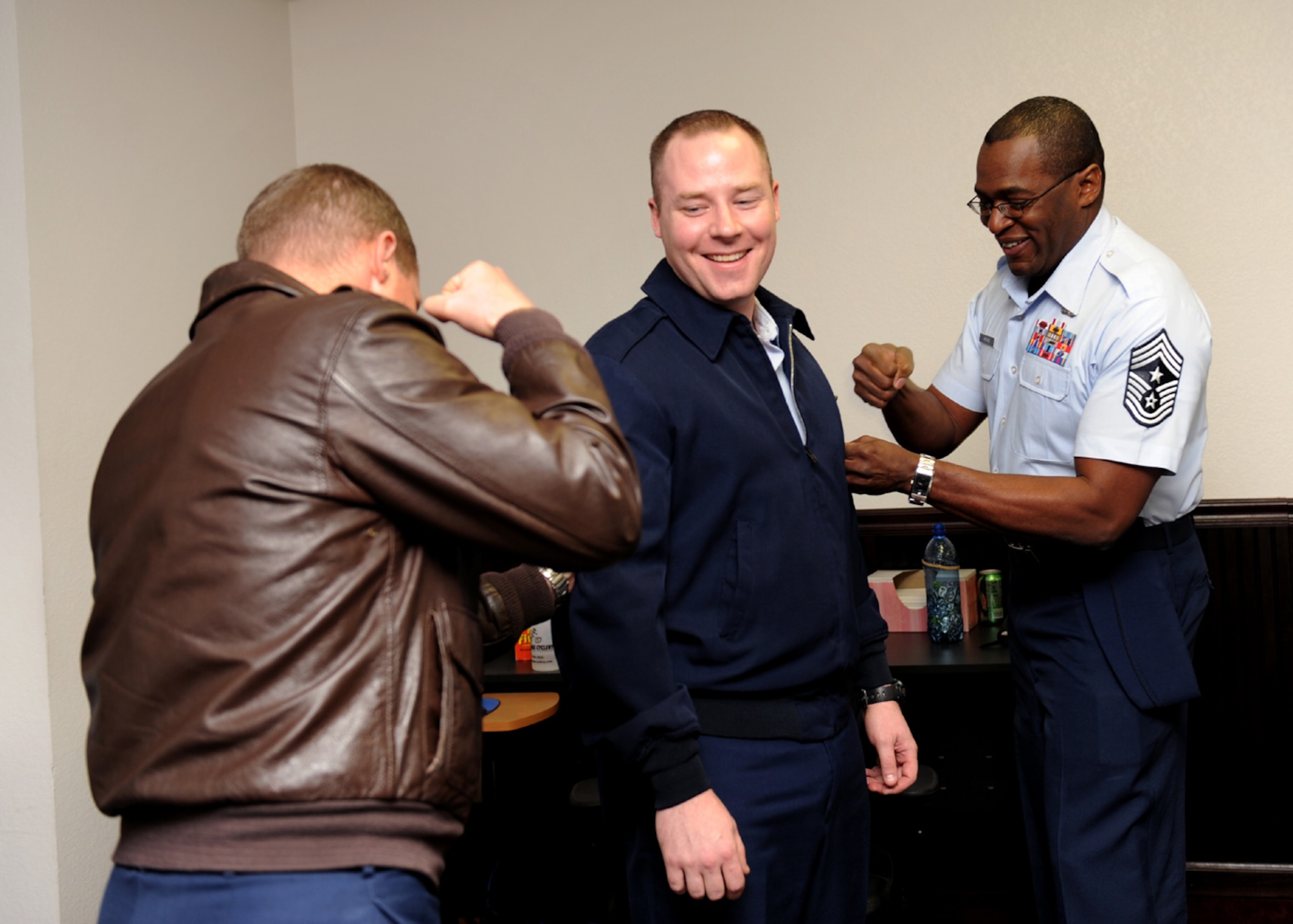 Staff Sgt. James Silcott, First Term Airman Course non commissioned officer in charge, receives his new Tech. Sgt. stripes from Col. Dave Belote, 99th Air Base Wing commander, and Chief Master Sgt. Alfred Herring, 99th Air Base Wing command chief, during a surprise Stripes for Exceptional Performance promotion ceremony at bldg. 625 Jan. 4. (U.S. Air Force photo by Airman 1st Class Brett Clashman)(Released)