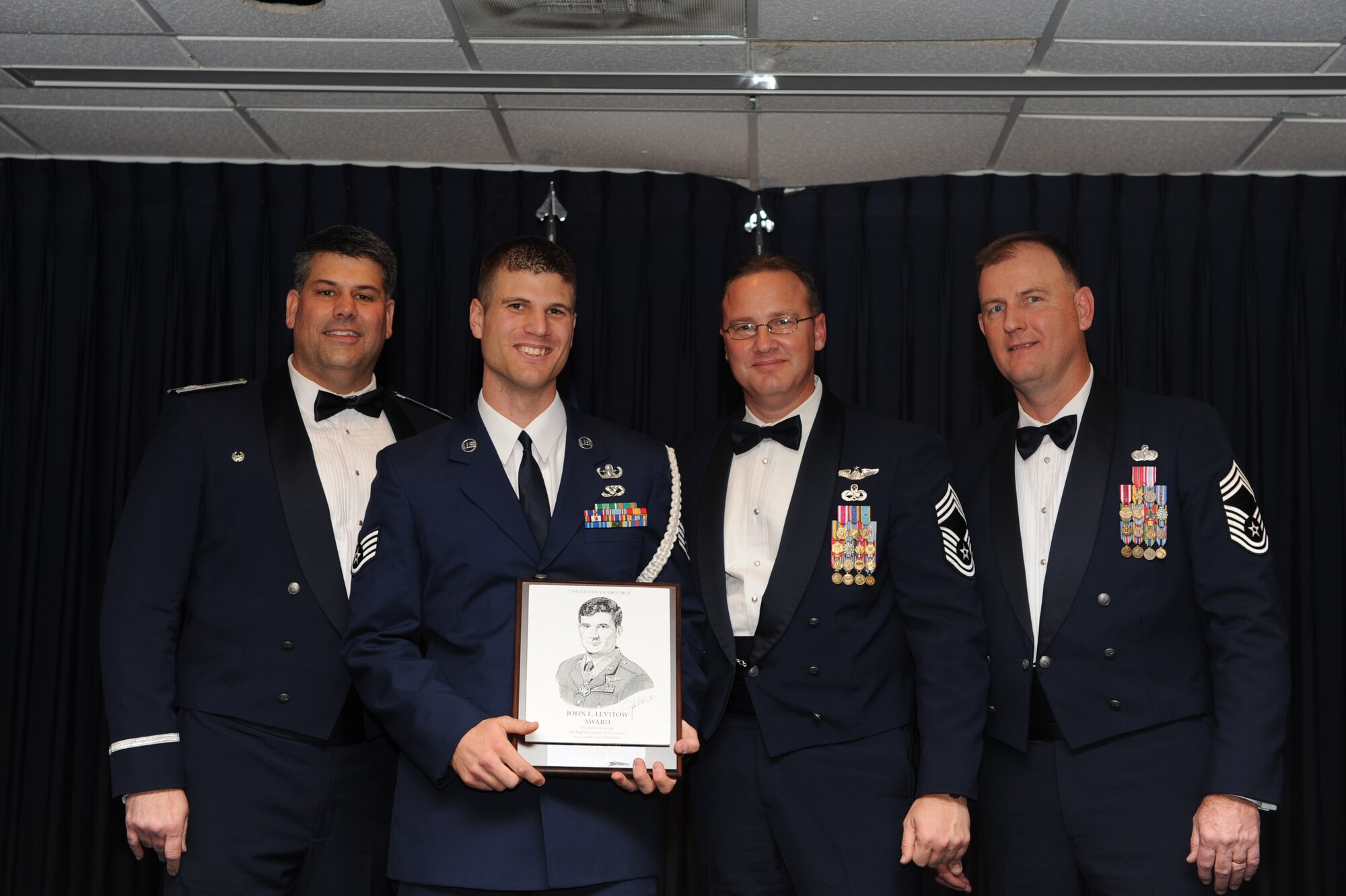 Staff Sgt. Paul Brow, 19th Civil Engineer Squadron, receives the John Levitow Award from base leaders Dec. 17 during the Airman Leadership Class graduation ceremony. The Levitow Award is presented to the top graduate of each ALS class. (U.S. Air Force Photo by Senior Airman Ethan Morgan)
