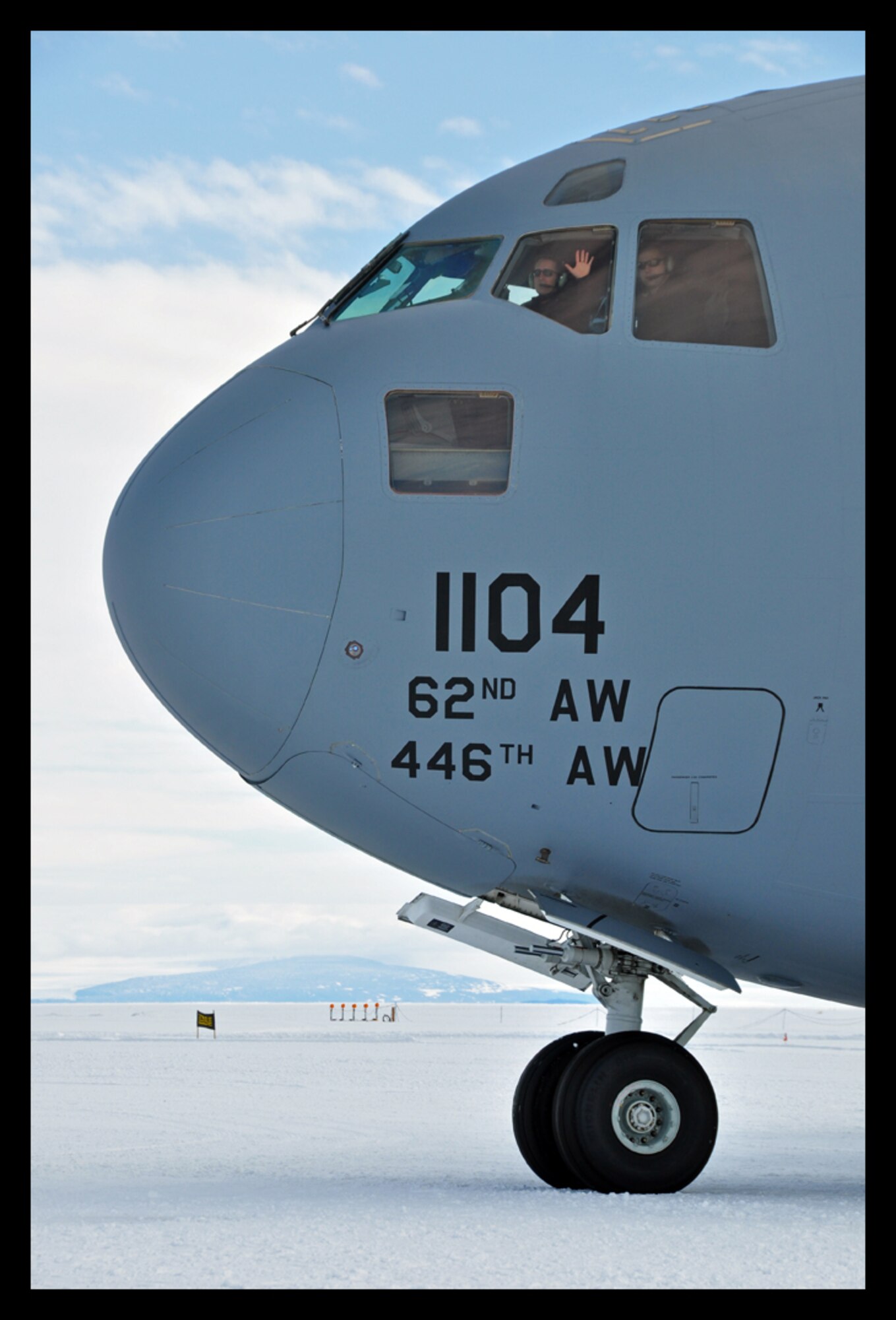 Lt. Col. Colin Keen, 313th Airlift Squadron pilot, gives a friendly wave before starting engines while detailing aircraft commander duties with Capt. Daniel Gasper, 728th Airlift Squadron pilot, at Pegasus Field, Antarctica during an Operation Deep Freeze mission. (U.S. Air Force photo/Staff Sgt. Robert Tingle)