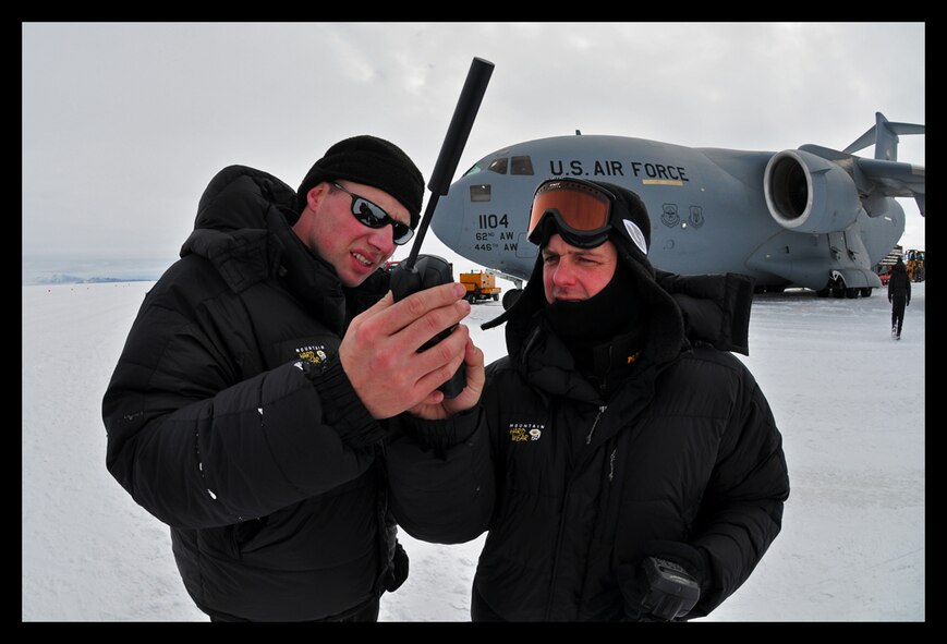 Capt. Rob Selmer, 97th Airlift Squadron, and Tech. Sgt. Quentin Nemechek, 446th Aircraft Maintenance Squadron, review satellite iridium phone operations at Pegasus Field, Antarctica, during an Operation Deep Freeze mission. (U.S. Air Force photo/Staff Sgt. Robert Tingle)