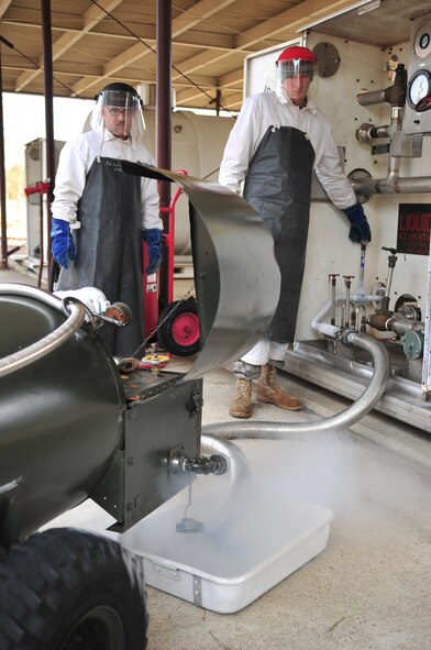 Staff Sgt. Joseph Olejniczak, (right) 4th Logistic Readiness Squadron terminal operations technician, shows Airman 1st Class Michael Tipton, 4th LRS distribution technician, how to purge a liquid oxygen line before filling a container for transport on Seymour Johnson Air Force Base, N.C., Jan. 5, 2010. Liquid oxygen is used in aircraft during in-flight emergencies when the cabin loses pressure, so the aircrew can breathe. Sergeant Olejniczak hails from Santa Fe, Tenn., and Airman Tipton hails from El Paso, Texas. (U.S. Air Force photo/Airman 1st Class Rae Perry)