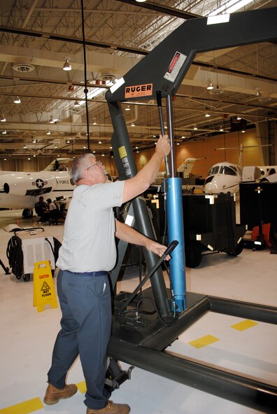 John Snook demonstrates the placement of a jack handle that prevented a T-1A Jayhawk engine from falling to the ground during an engine inspection Dec. 1. (U.S. Air Force photo/2nd Lt. Christopher Buzzetta)