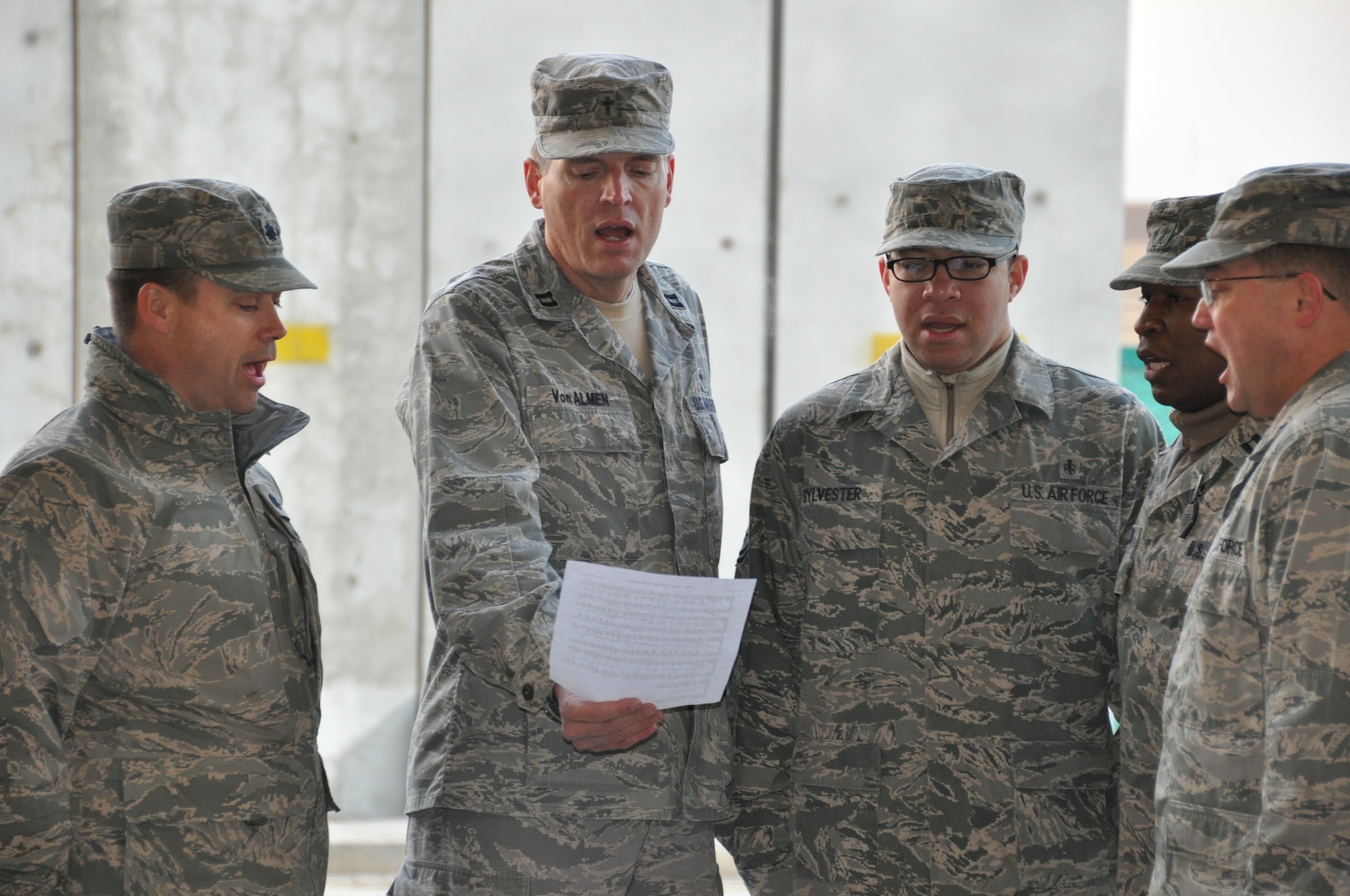 Chap. (Capt.) John Von Almen, 455th Air Expeditionary Wing Protestant chaplain, and fellow Airmen sing the National Anthem during an award ceremony at Bagram Air Field, Afghanistan. Chaplain Von Almen is deployed from the 4th Fighter Wing at Seymour Johnson Air Force Base, N.C. (Courtesy photo)