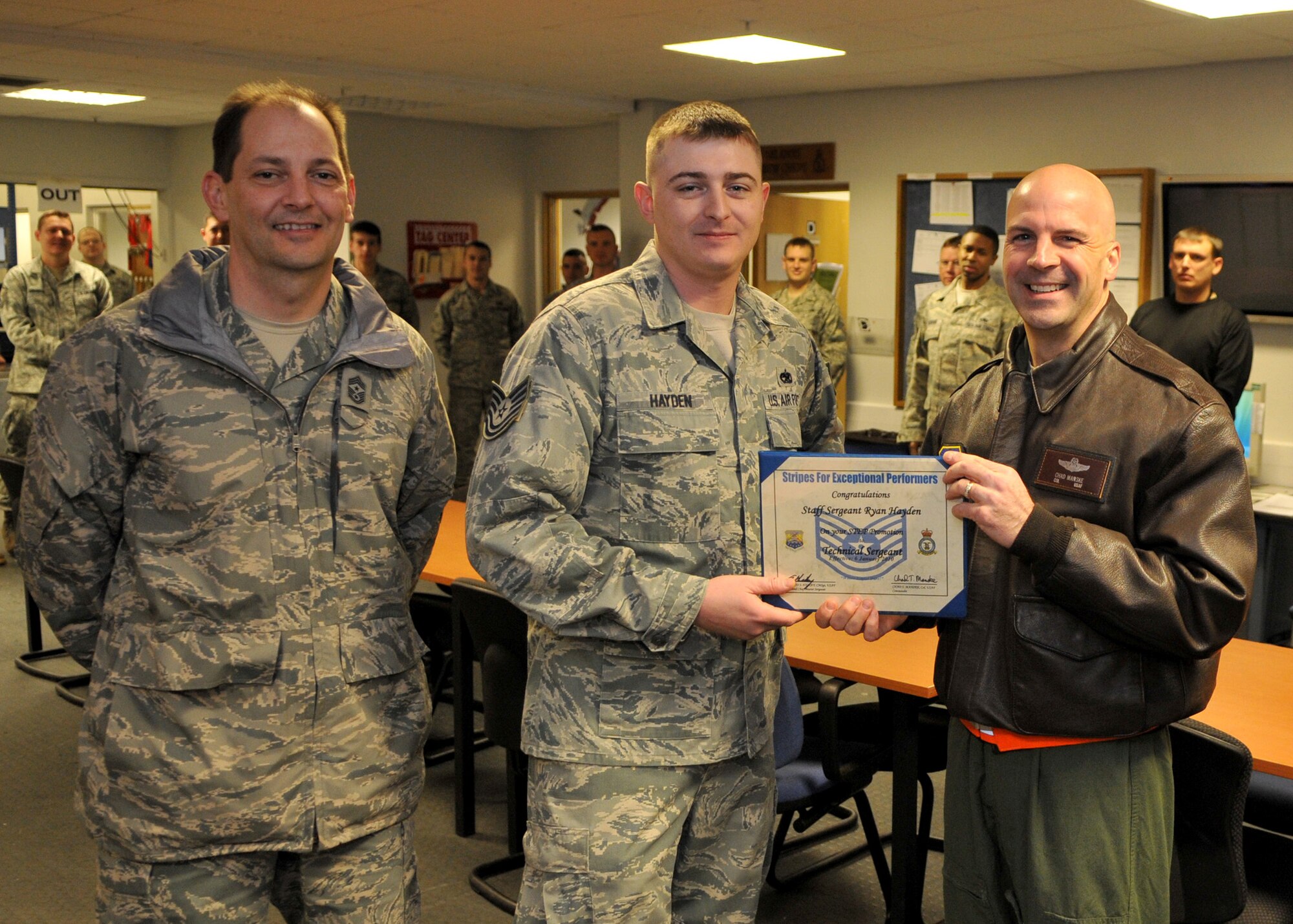 RAF MILDENHALL, England – Staff Sgt. Ryan Hayden, 100th Aircraft Maintenance Squadron instruments flight systems craftsman, is promoted to the rank of technical sergeant under the Stripes for Exceptional Performers program by Col. Chad Manske, 100th Air Refueling Wing commander and Chief Master Sgt. Antonio Hickey, 100th Air Refueling Wing command chief, Jan. 6. The STEP program is a highly visible promotion recognition program used by commanders at all levels to recognize the outstanding contributions and accomplishments of senior airmen, staff sergeants and technical sergeants. (U.S. Air Force photo/ Staff Sgt. Jerry Fleshman)