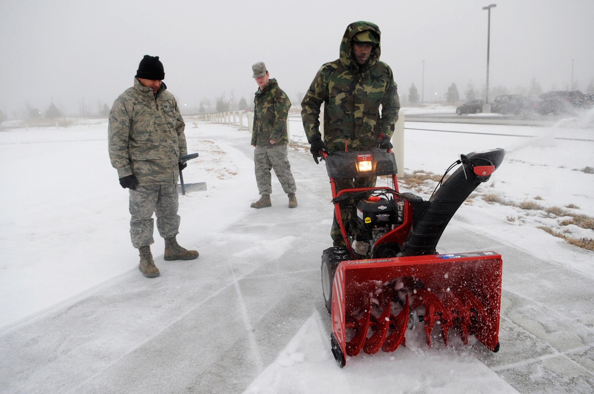 BUCKLEY AIR FORCE BASE, Colo. -- 460th Space Communications Squadron project managers Senior Airman Darnell Walcott, right, Tech. Sgt. Daniel Trigo, left, and Senior Airman Joshua Snook clear the sidewalks Jan 6. Winds here are expected to exceed 40 miles per hour.  (U.S. Air Force photo by Senior Airman Kathrine McDowell)