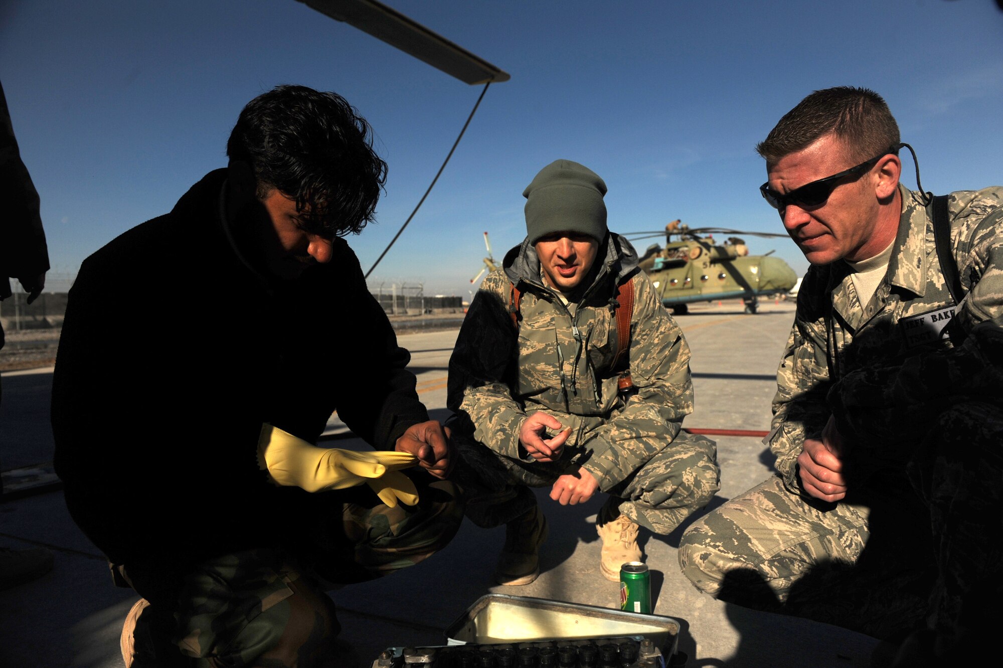 738th Air Expeditionary Maintenance advisors, Staff Sgt. Paul Butler (middle) and Tech. Sgt. Jeff Baker (right), check an Afghanistan National Army Air Corps soldier?s work on an MI-17 helicopter battery at Kandahar Air Field, Afghanistan, Jan. 5, 2010. Sergeant Butler is deployed from Tinker AFB, Okla. and Sergeant Baker is from Barksdale AFB, La.  (U.S. Air Force photo/Staff Sgt. Manuel J. Martinez/Released)