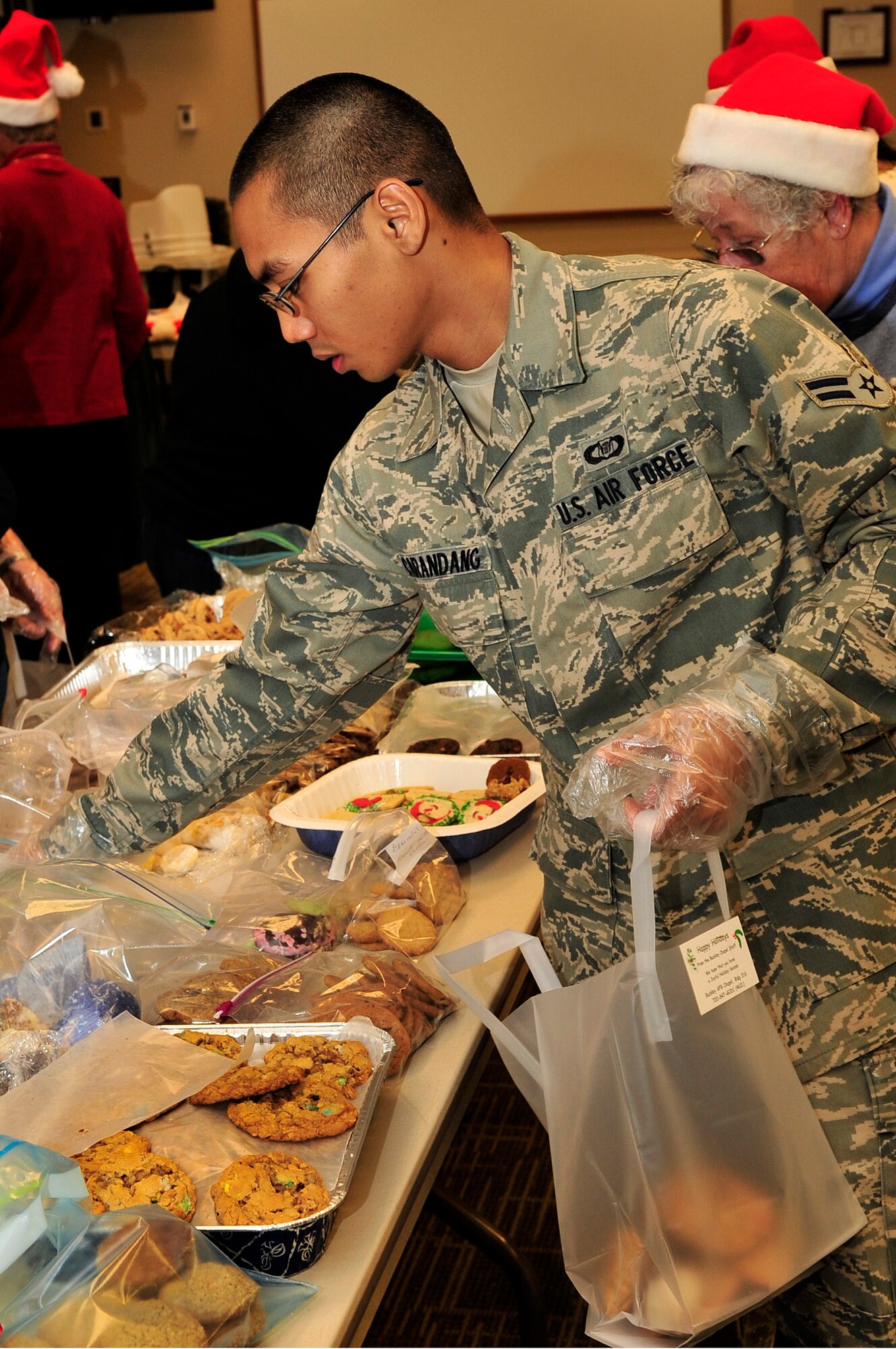 BUCKLEY AIR FORCE BASE, Colo. -- Airman 1st class Joshua Carandang bags cookies for the 12th annual cookie caper at the base chapel, Dec. 15, 2009. Carandang voluntered his time to help out before attending duty. (U.S. Air Force photo by Airman 1st Class Manisha Vasquez) 