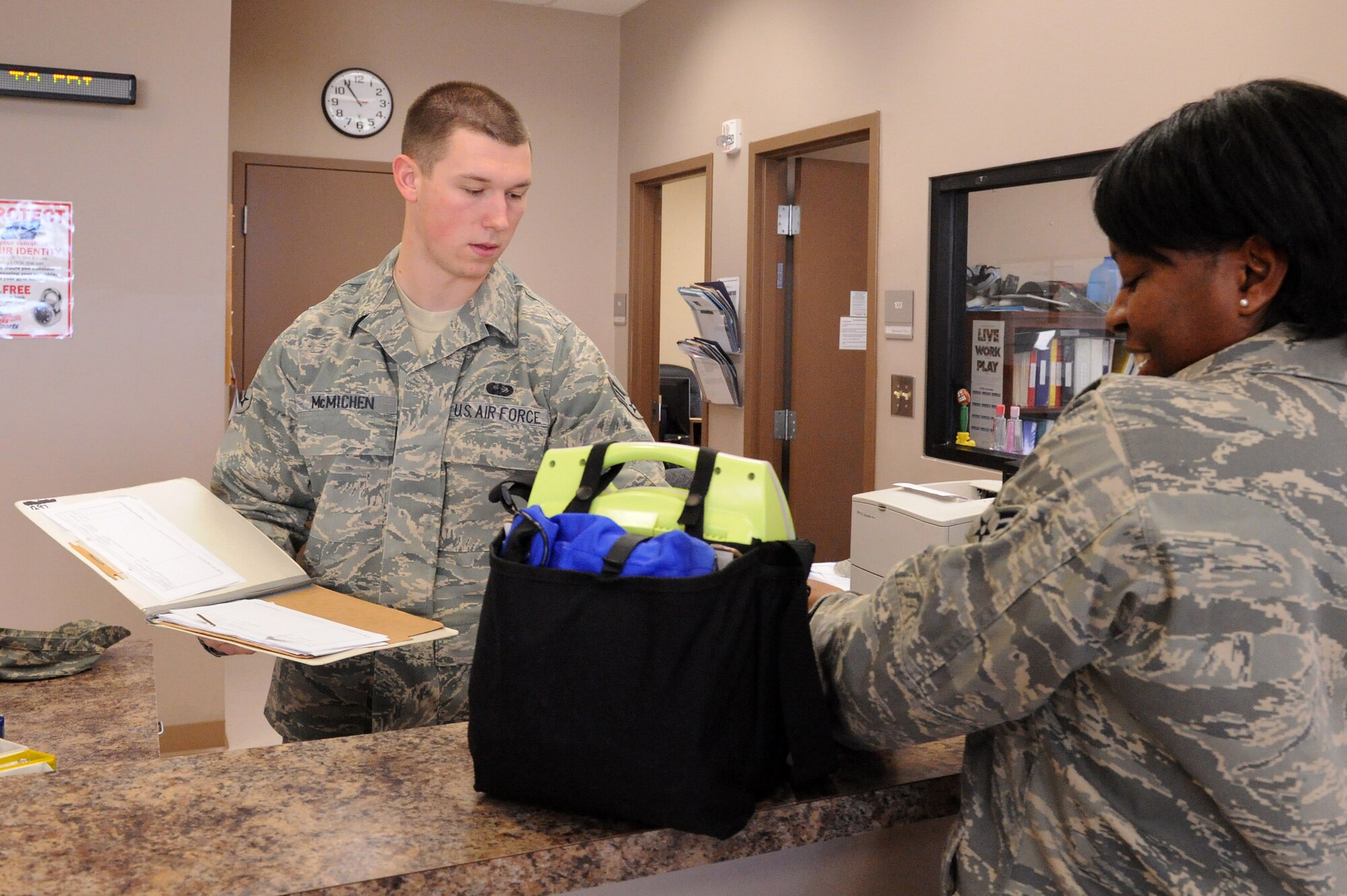 Senior Airman Adam McMichen, 4th Force Support Squadron fitness and sports specialist, checks out an automated external defibrillator to Senior Airman Latronette Stoney, 916th Air Refueling Wing service apprentice and unit physical training leader, on Seymour Johnson Air Force Base, N.C., Jan. 4, 2010. It is mandatory to have an automated external defibrillators available during physical training test in case of a emergency.  The device automatically analyzes the heart rhythm and, if it detects a problem the AED will respond with an electrical shock to get a heart back to its normal rhythm. (U.S. Air Force photo/Senior Airman Whitney Lambert)